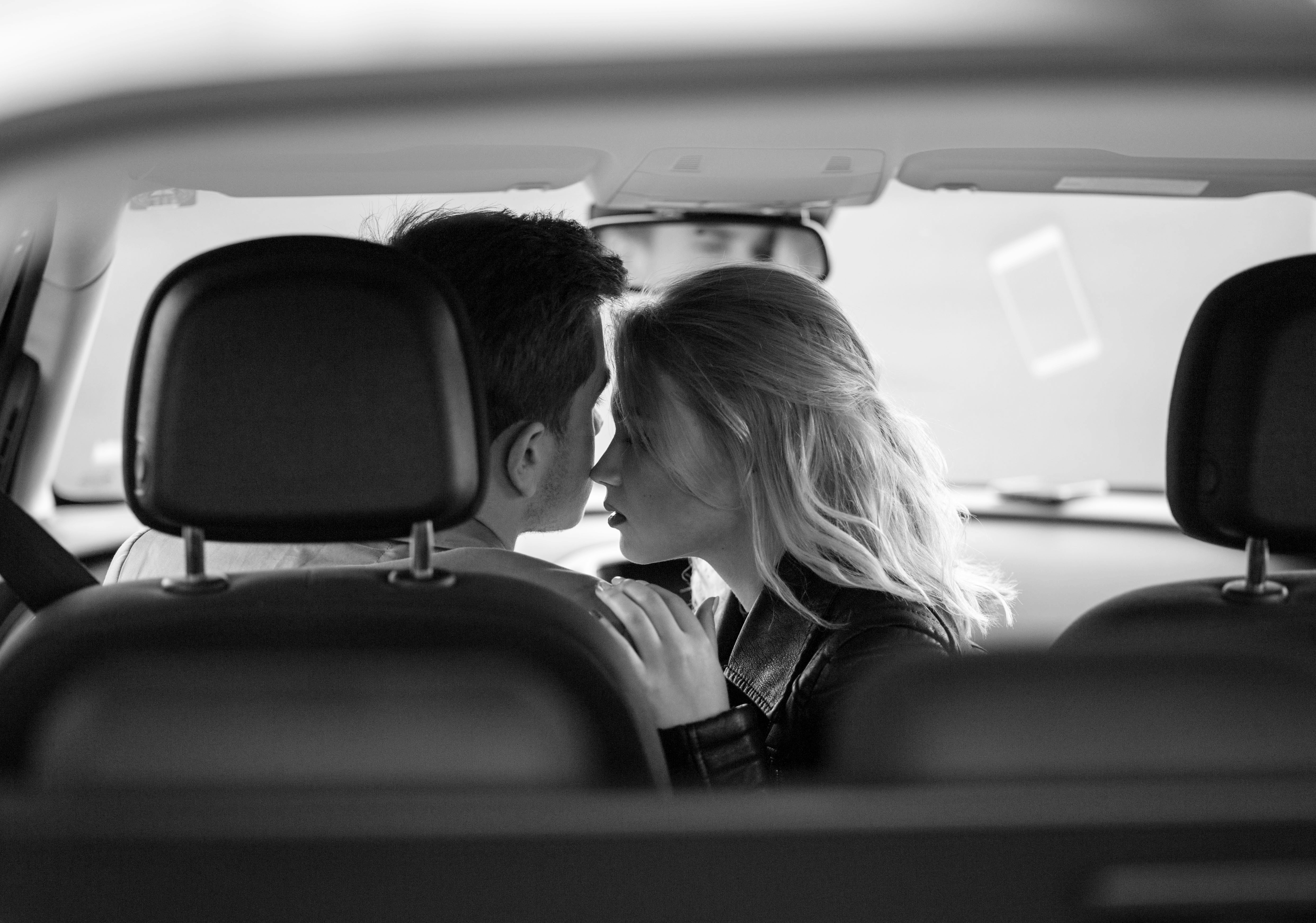Pareja besándose románticamente en Automóvil. | Fuente: Shutterstock