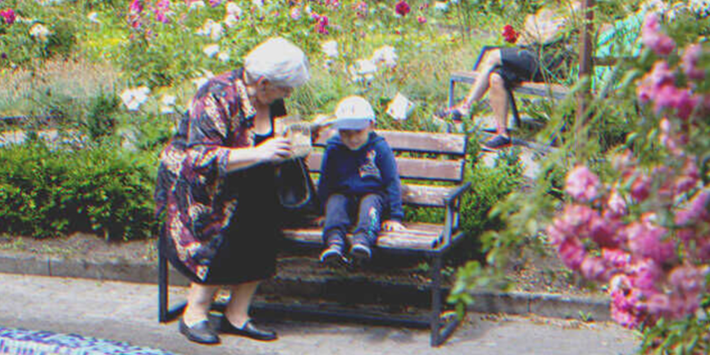 Una mujer mayor y un niño en un banco de plaza | Foto: Shutterstock