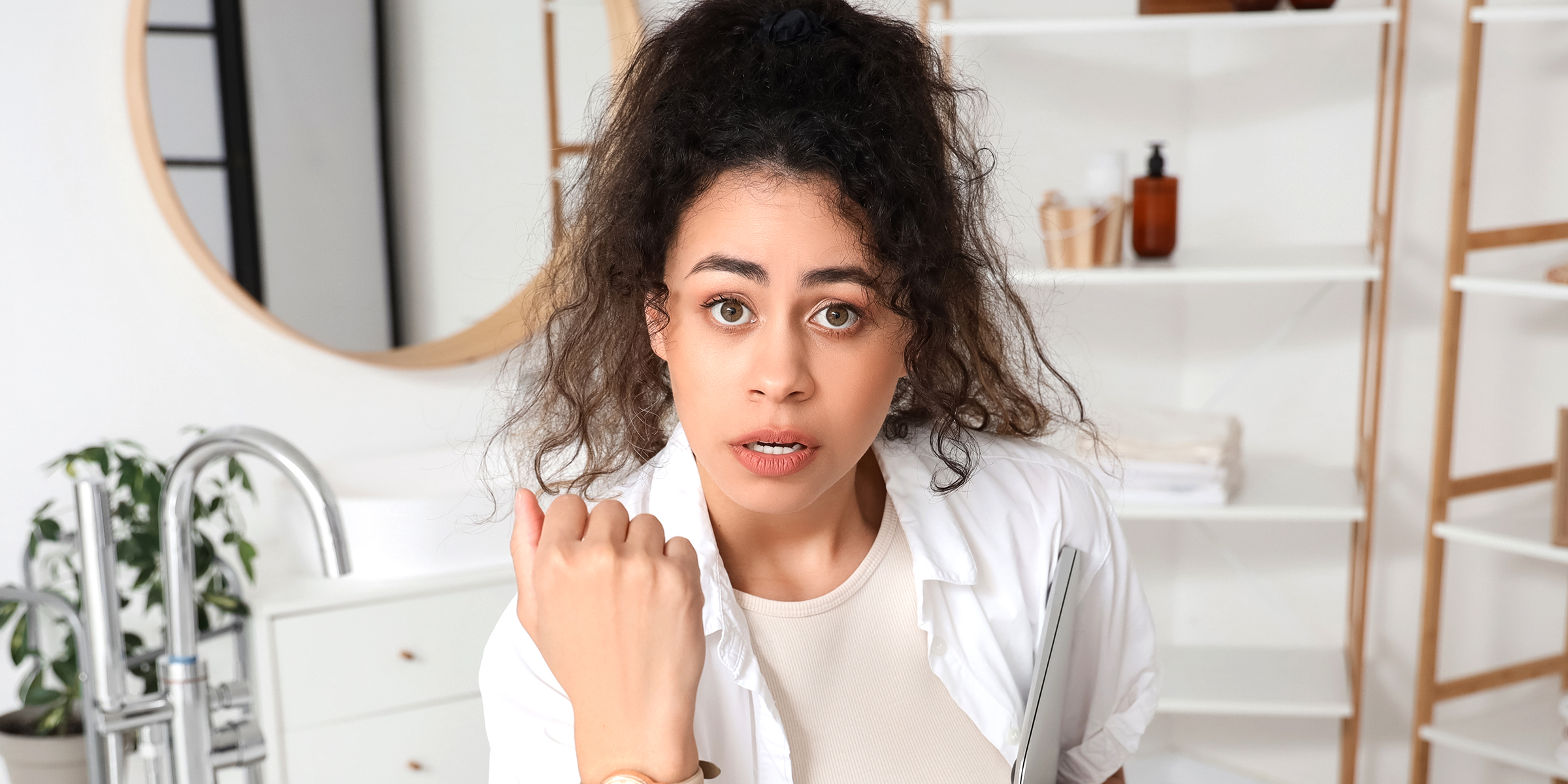 Mujer sorprendida en un cuarto de baño | Fuente: Shutterstock