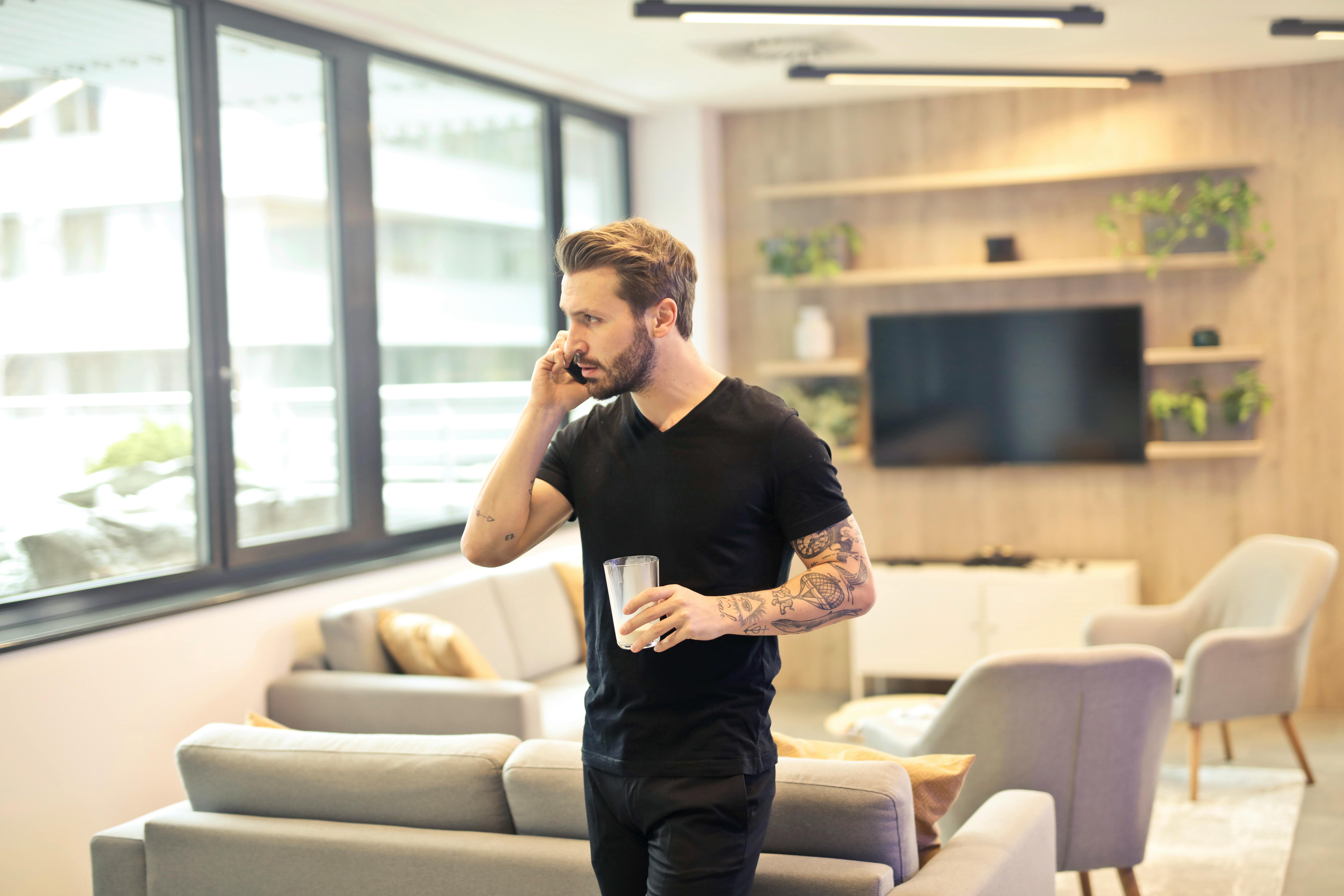 Hombre con una bebida habla por teléfono | Foto: Pexels