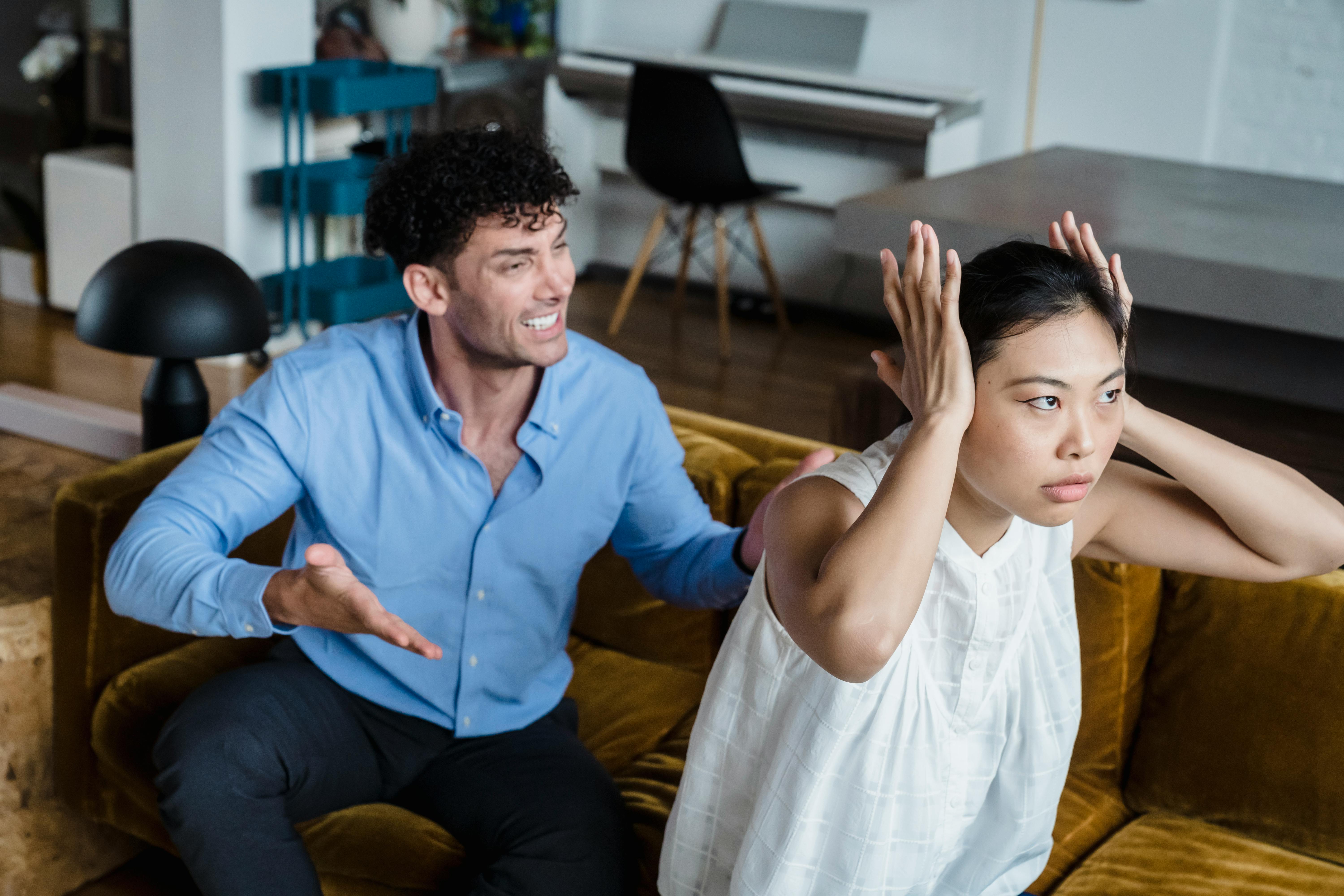 Una pareja discutiendo sentada en un sofá | Fuente: Pexels