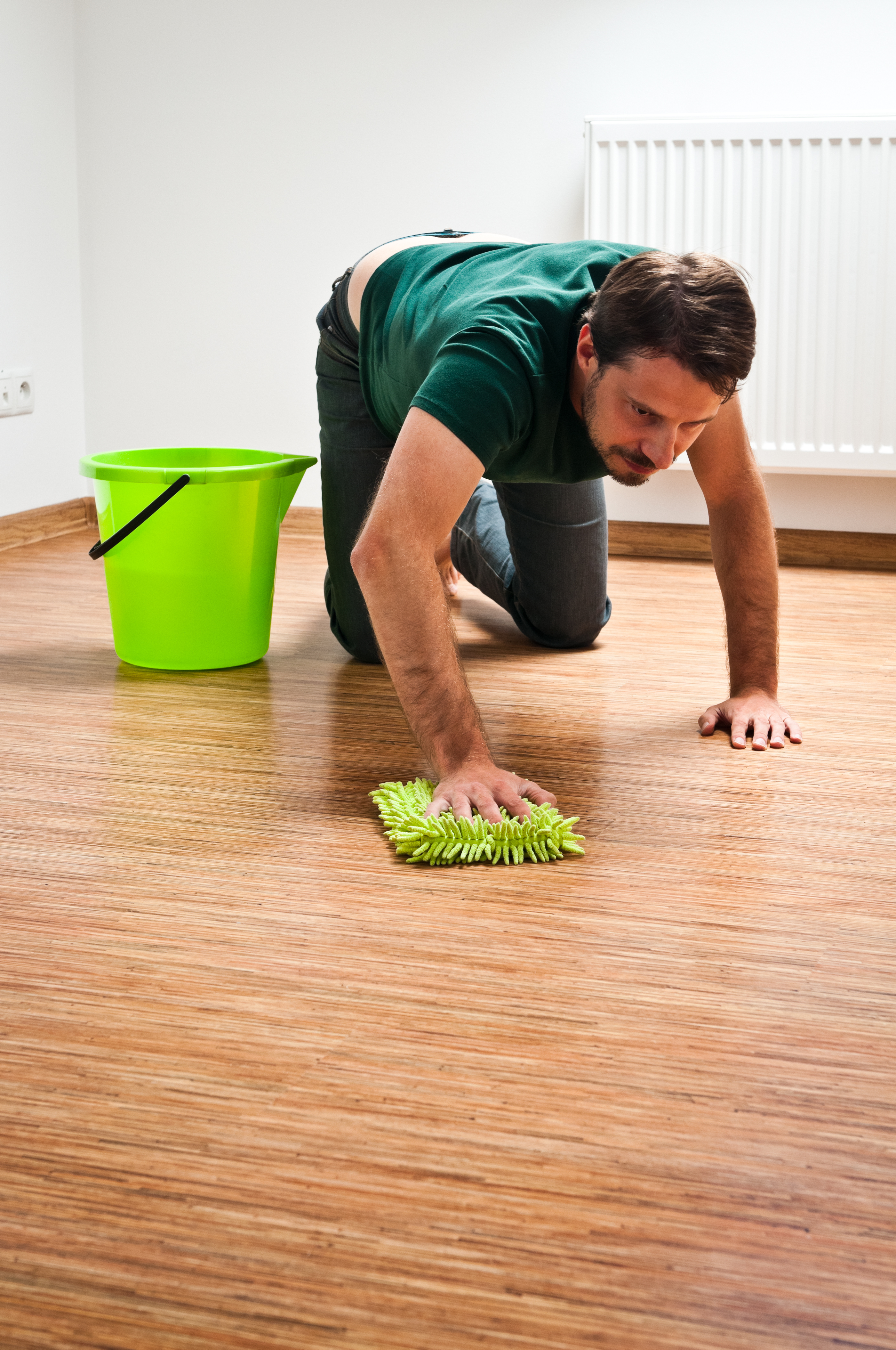 Un hombre limpiando el suelo de su casa | Fuente: Getty Images