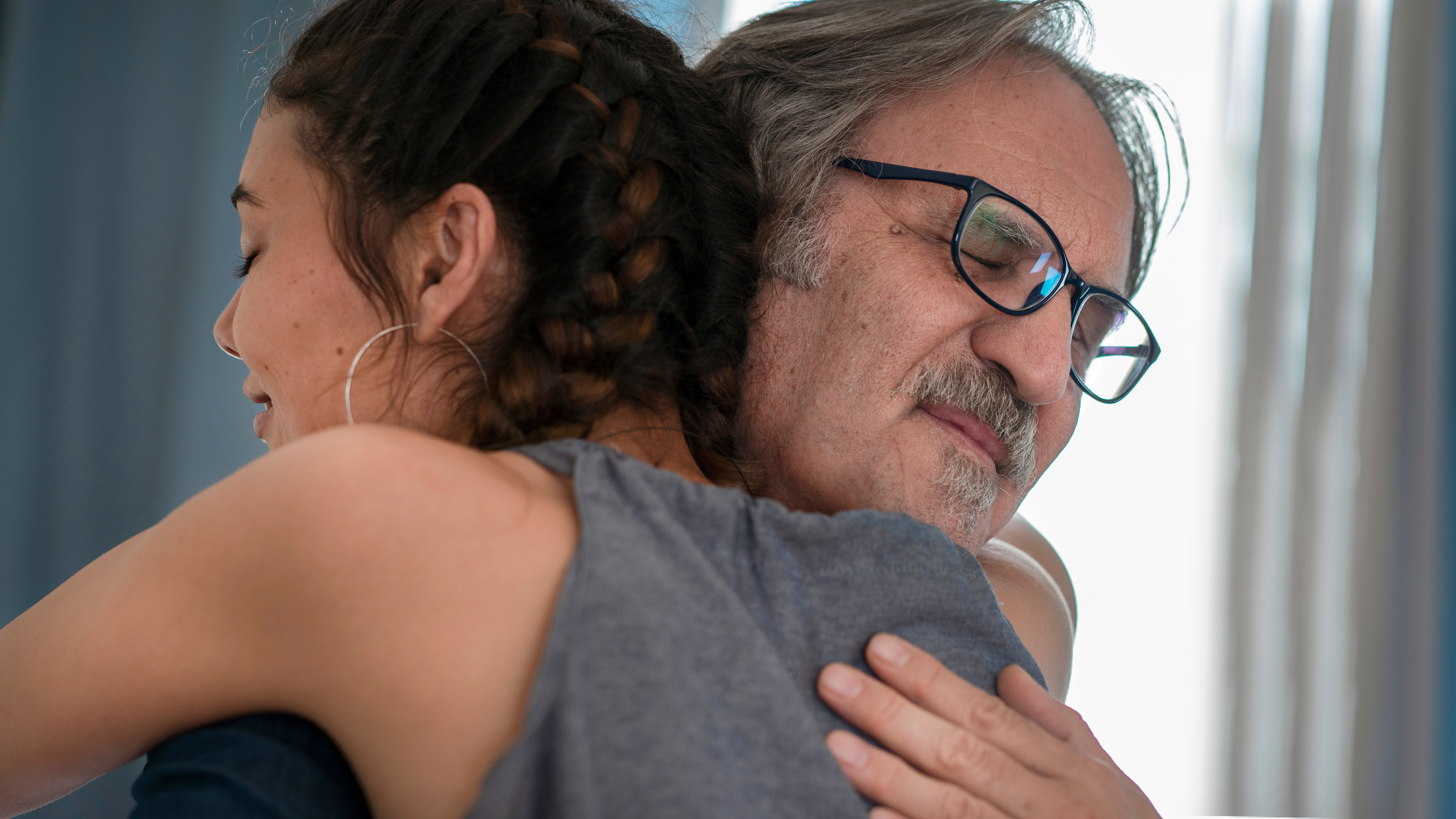 Un hombre mayor abraza a una mujer más joven | Foto: Shutterstock