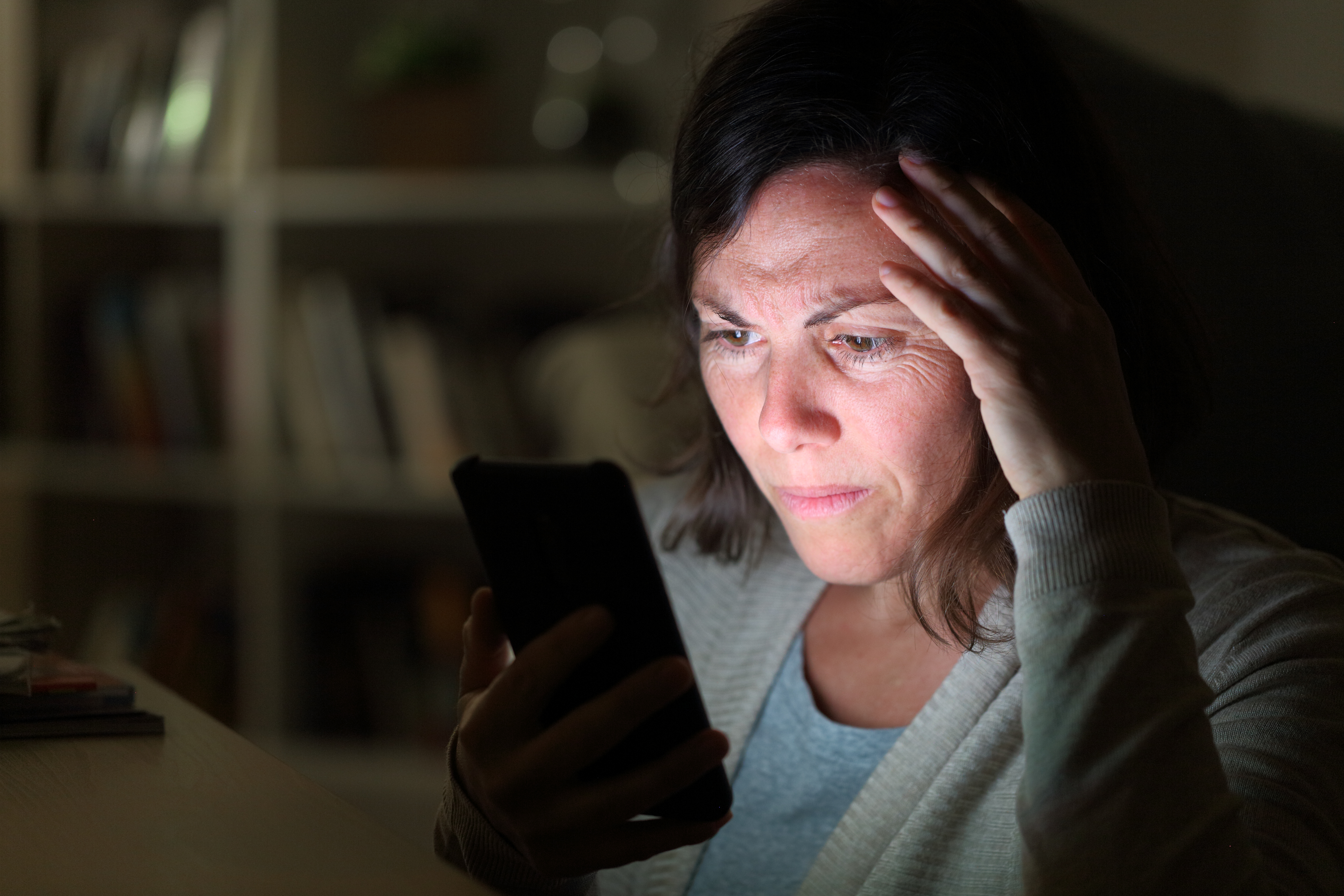 Una mujer preocupada mira su móvil | Fuente: Shutterstock