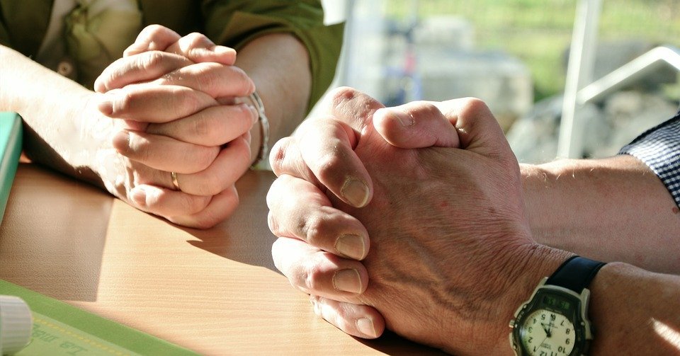 Personas orando con las manos entrelazadas. │Foto: Pixabay