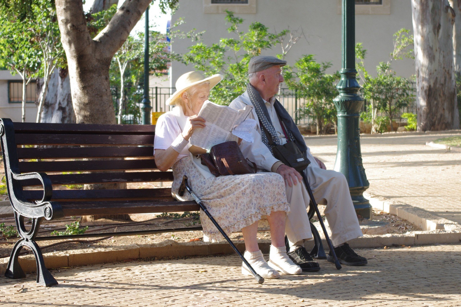 Pareja de ancianos sentada en el banquillo de un parque. | Foto: Public Domain Pictures