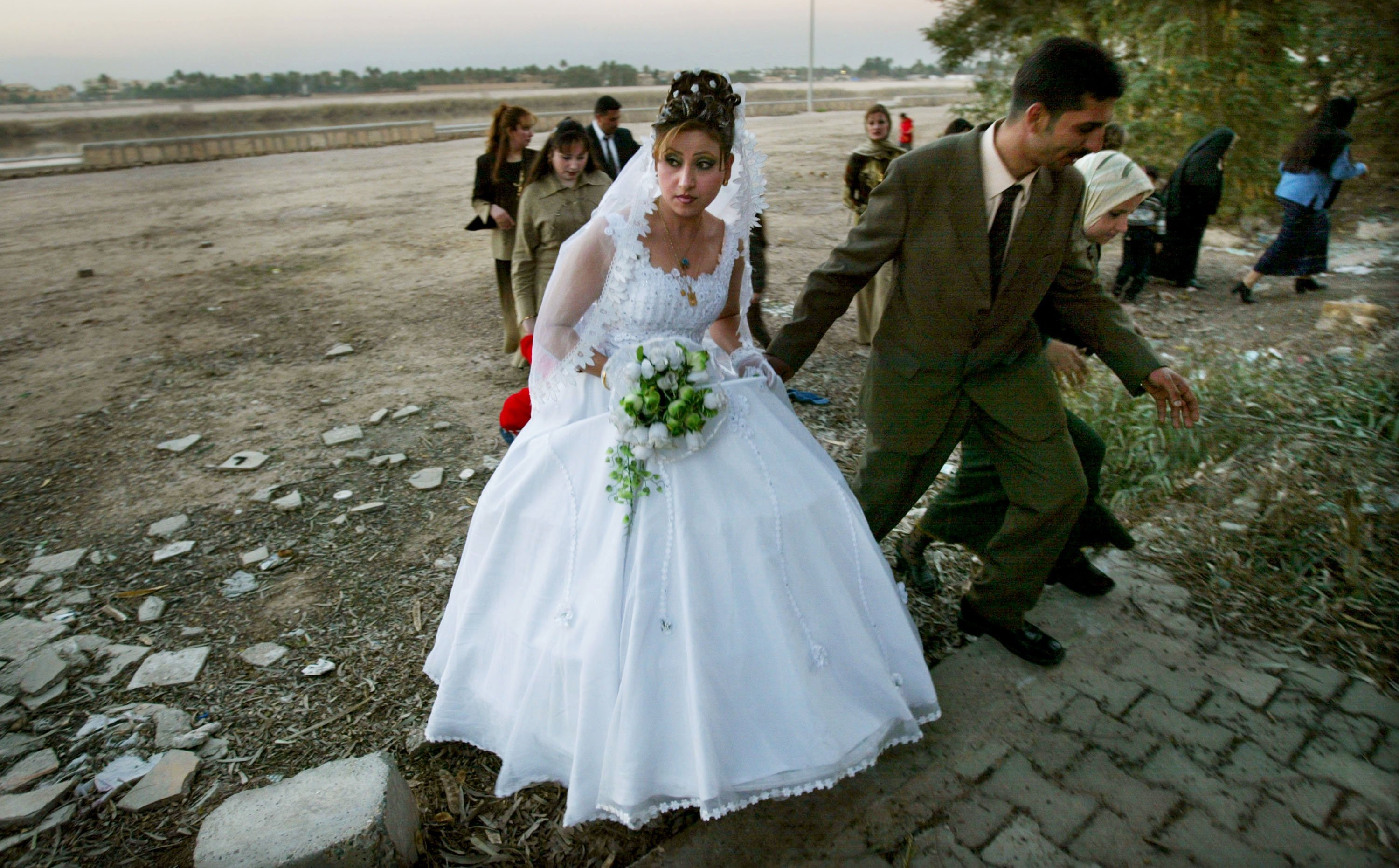 Una pareja iraquí recién casada se aleja de las orillas del río Tigris después de posar para fotografías el 9 de febrero de 2004 en Bagdad, Irak. | Foto: Getty Images 