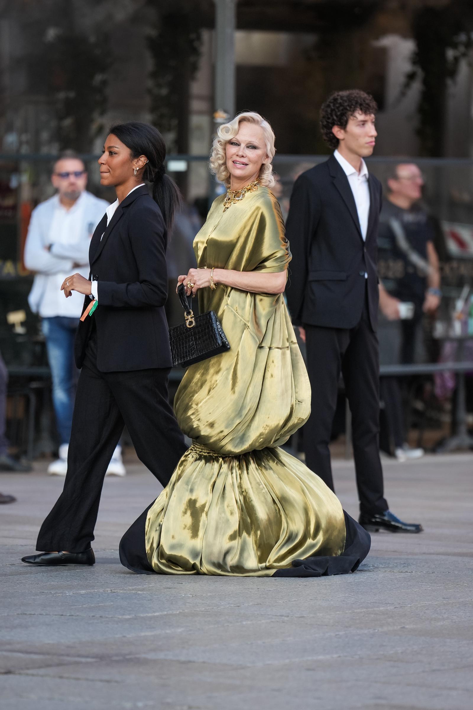 Anderson se dirige hacia la vitrina con el bolso en la mano, dejando al descubierto la espectacular falda abullonada del vestido, que se extiende hasta casi tocar el suelo. | Fuente: Getty Images