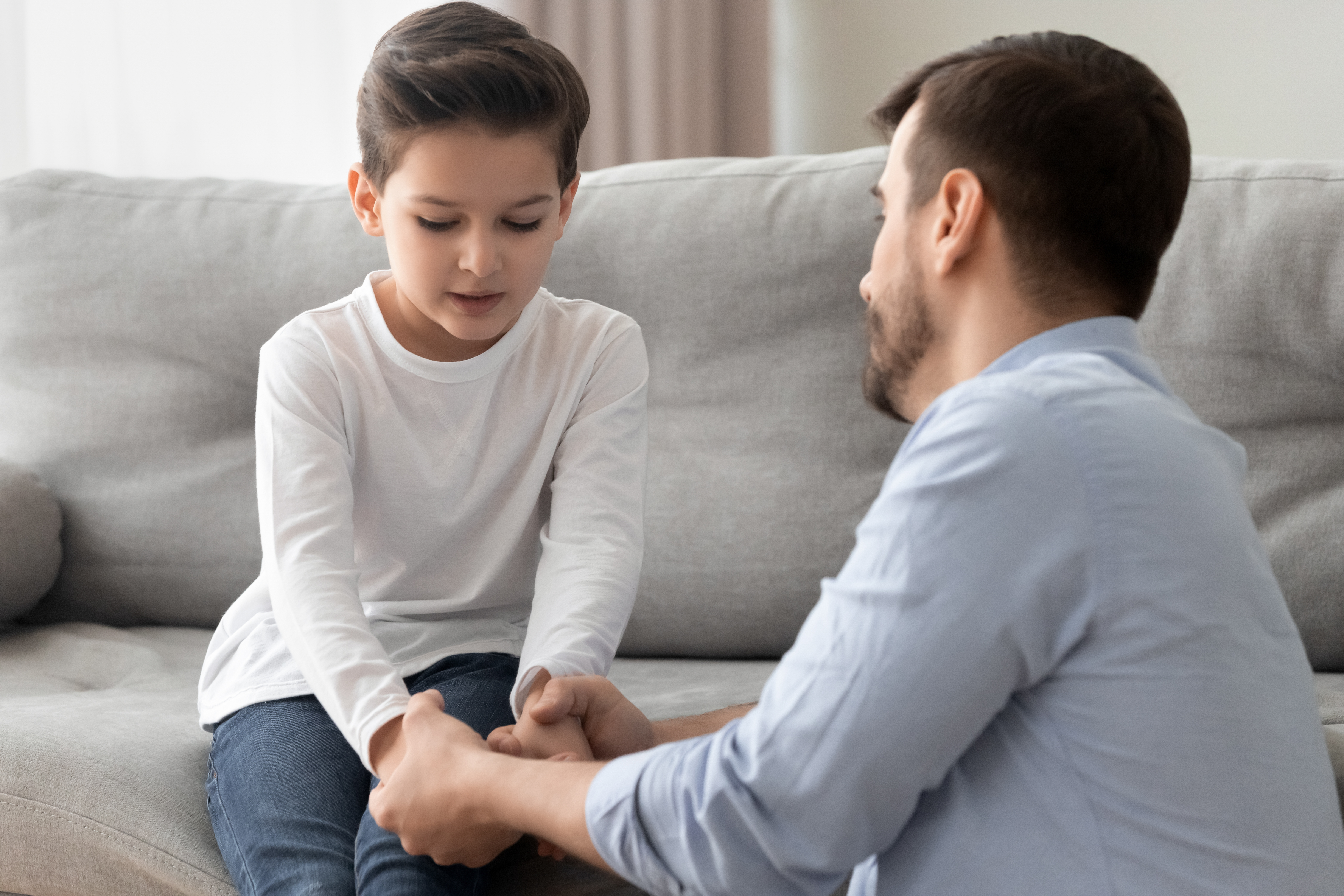 Un niño triste habla con su padre | Fuente: Shutterstock.com