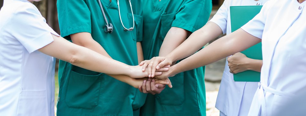 Equipo de enfermeros uniendo sus manos. I Foto: Shutterstock