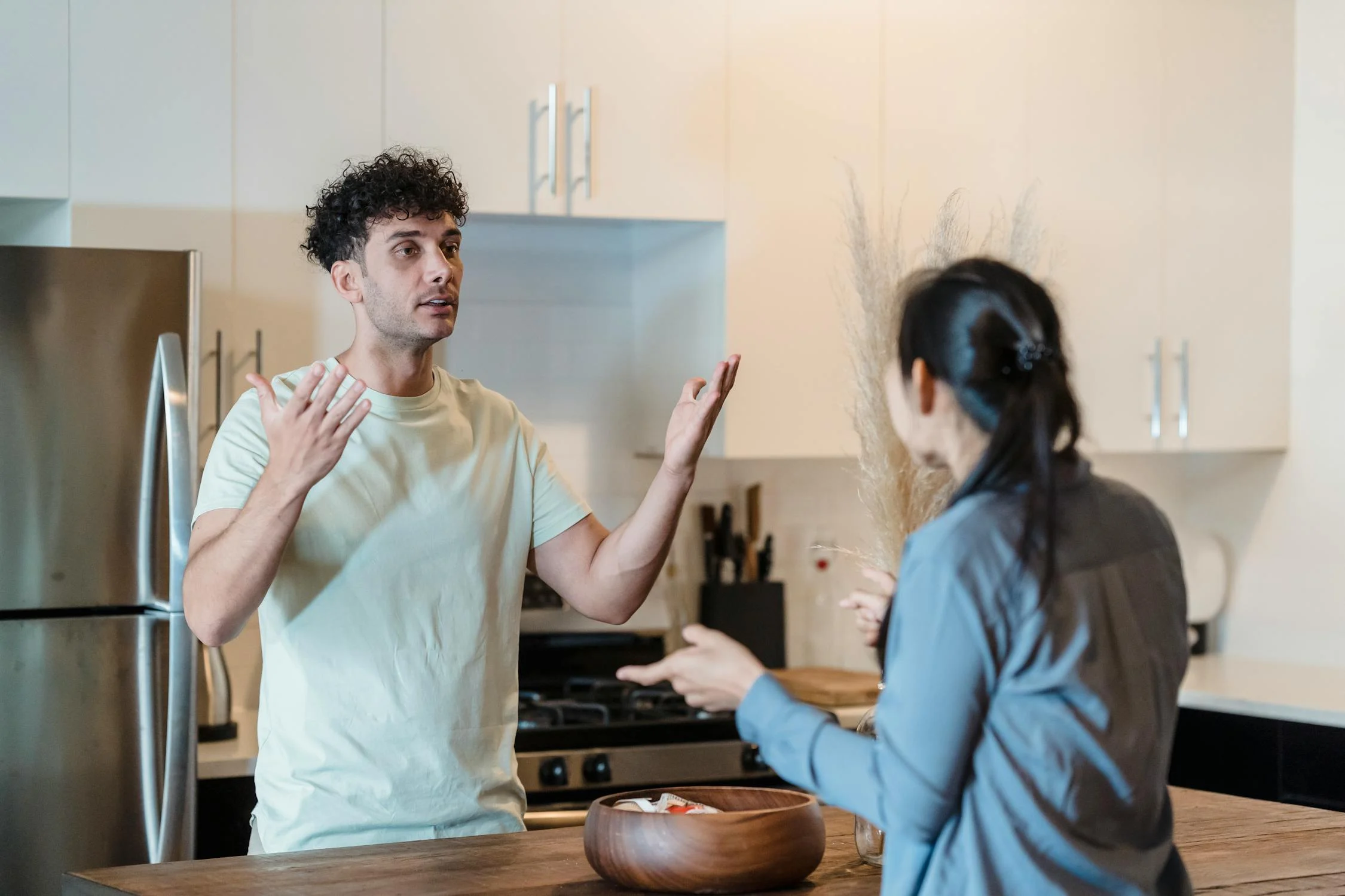 Un hombre hablando con su mujer en la cocina | Fuente: Pexels