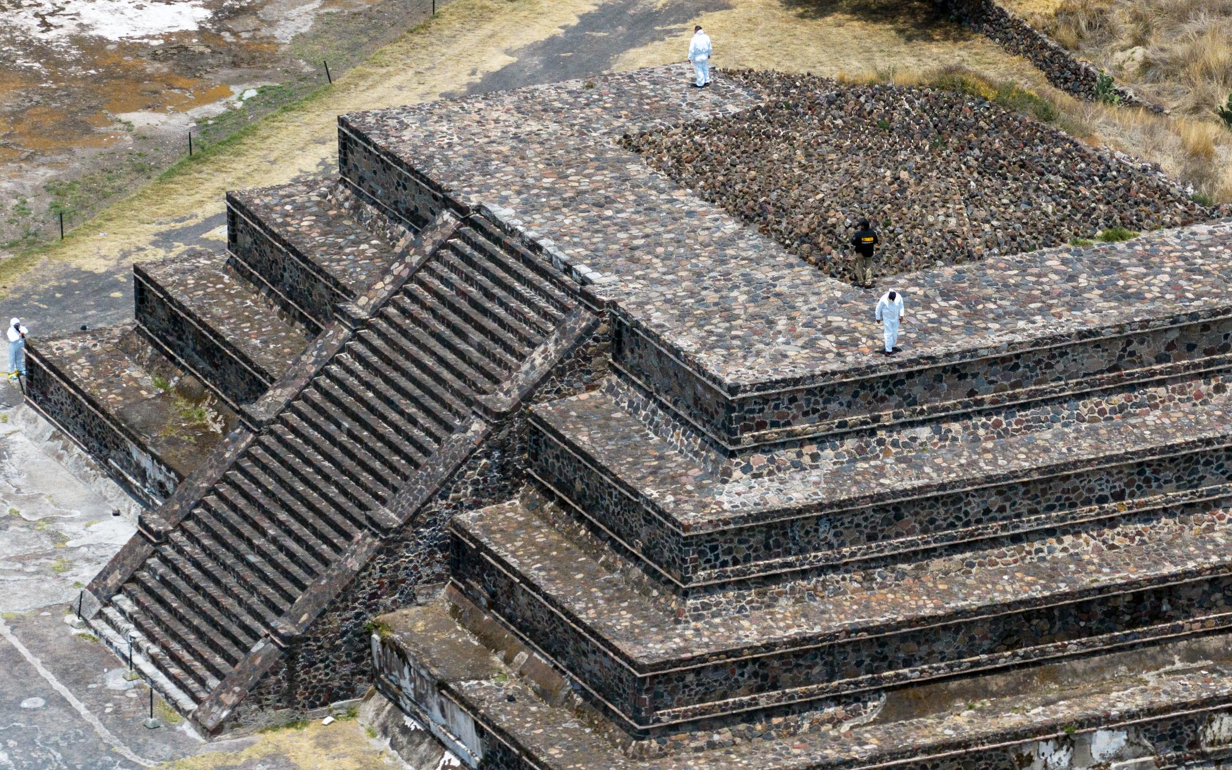 Esta vista aérea muestra a expertos forenses y personal de la Fiscalía trabajando en la zona arqueológica de Teotihuacán tras un tiroteo ocurrido en Teotihuacán, Estado de México, el 21 de abril de 2026. | Fuente: Getty Images.