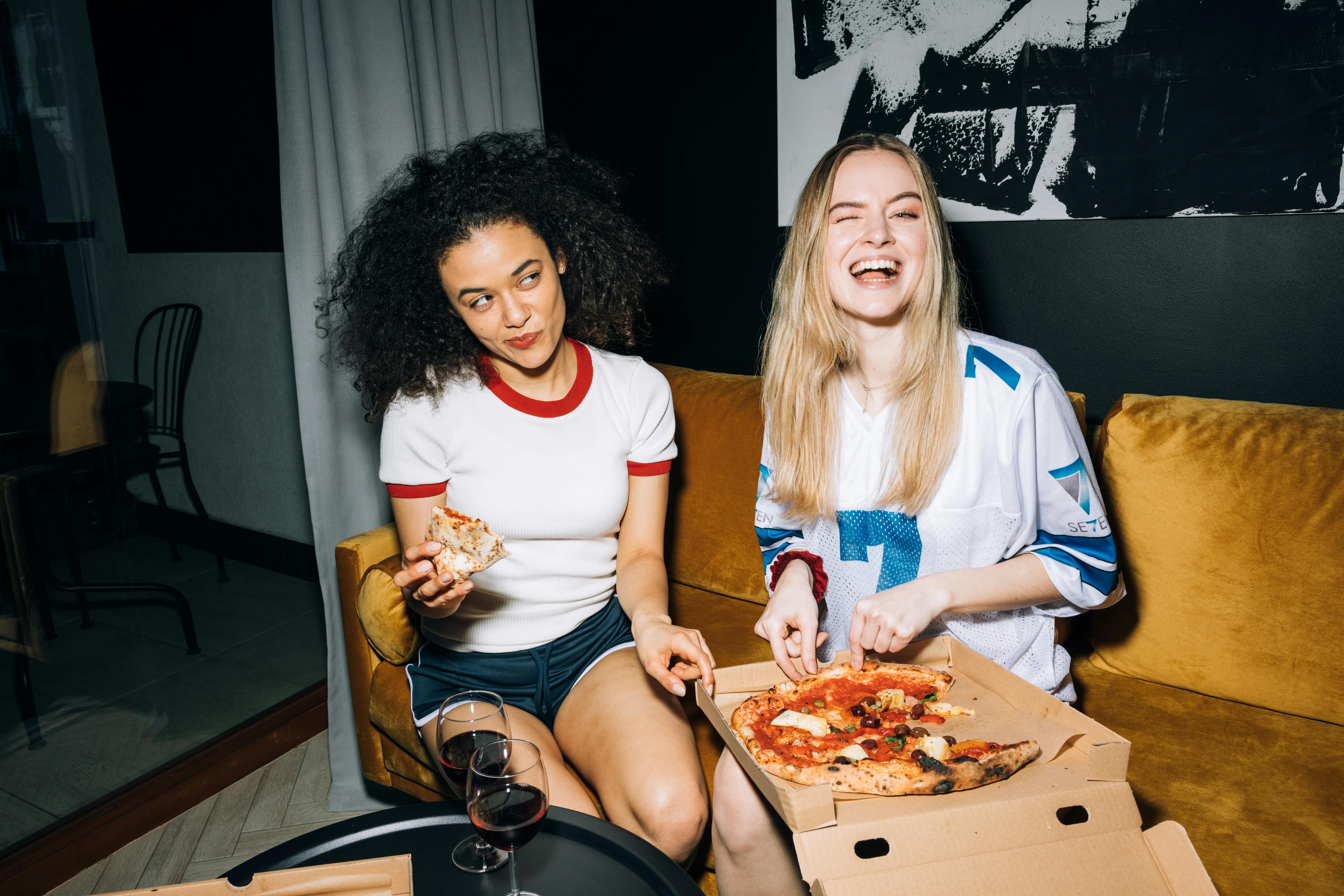 Dos chicas disfrutando de una pizza | Fuente: Pexels