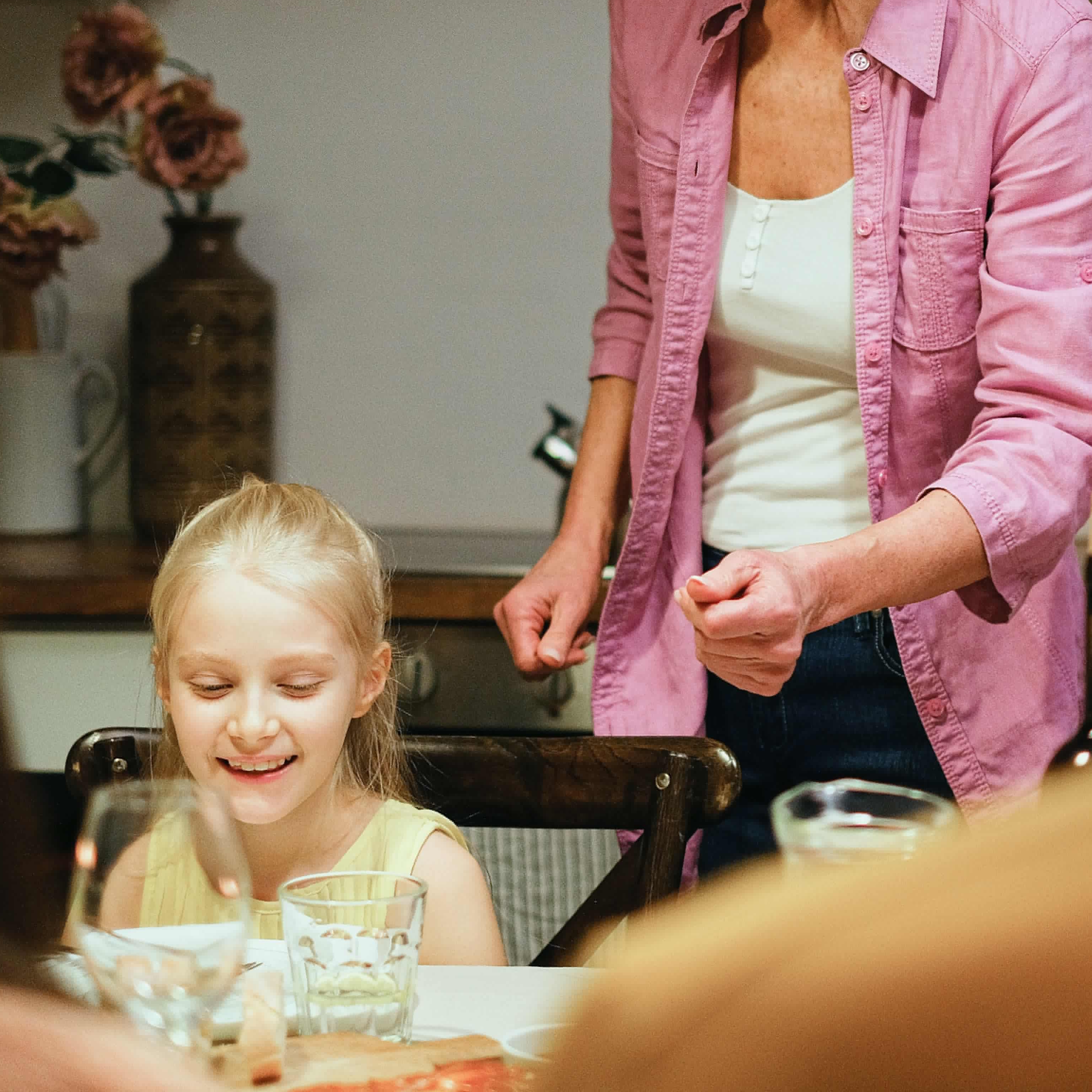 Una mujer preparando la cena para los niños en una mesa | Fuente: Pexels