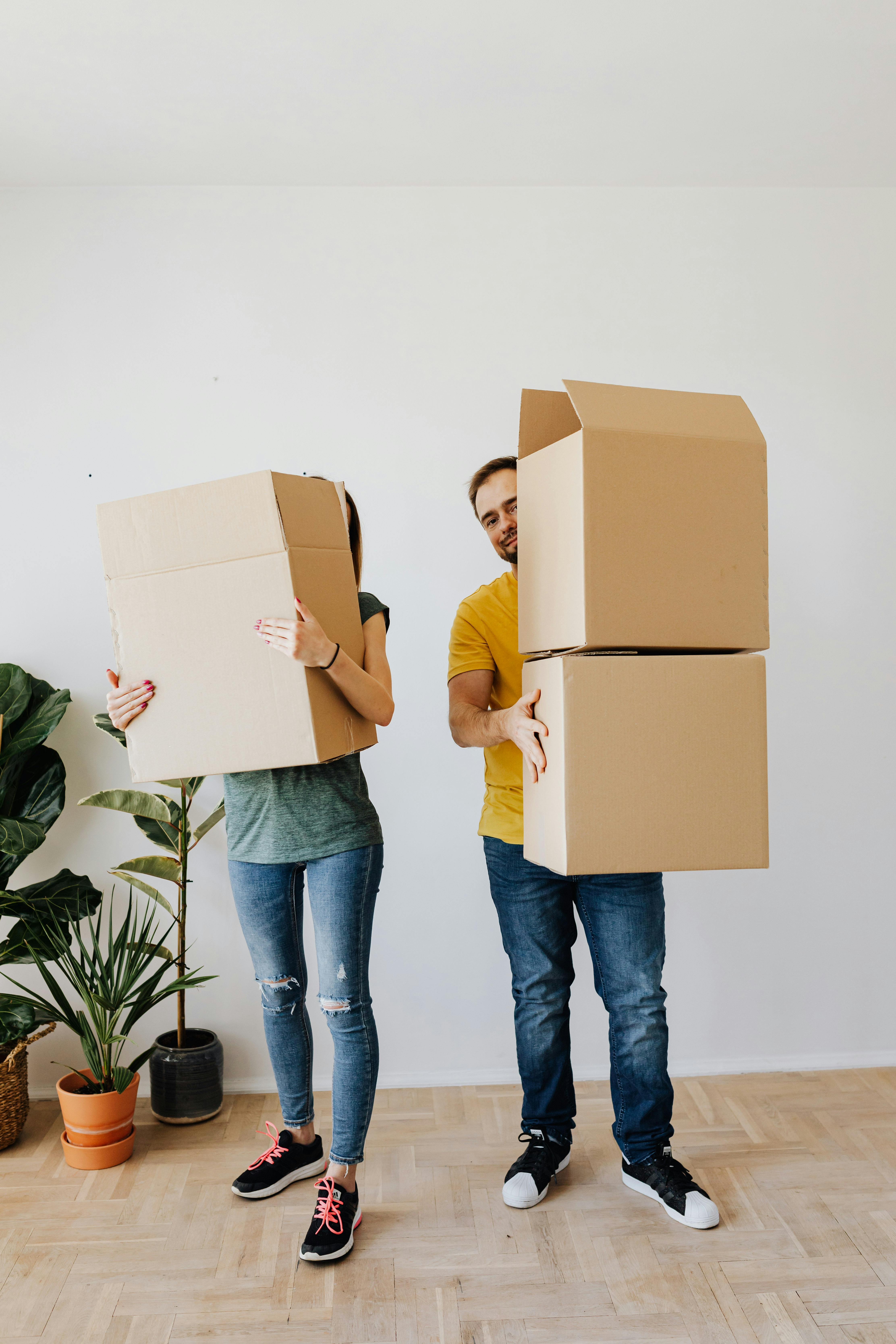 Una pareja sujetando cajas lista para mudarse | Fuente: Pexels