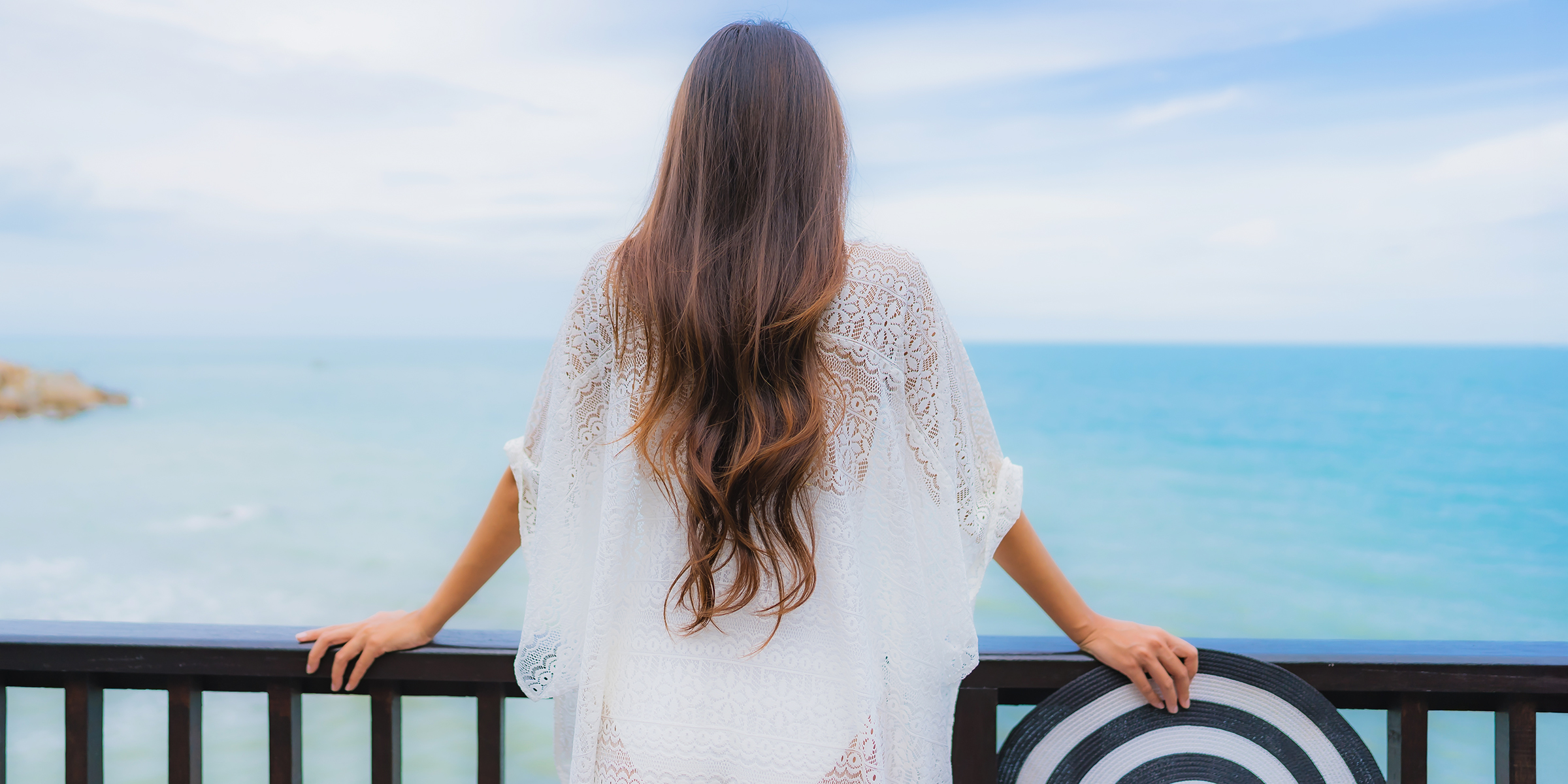 Una mujer mirando al mar desde un balcón | Fuente: Shutterstock