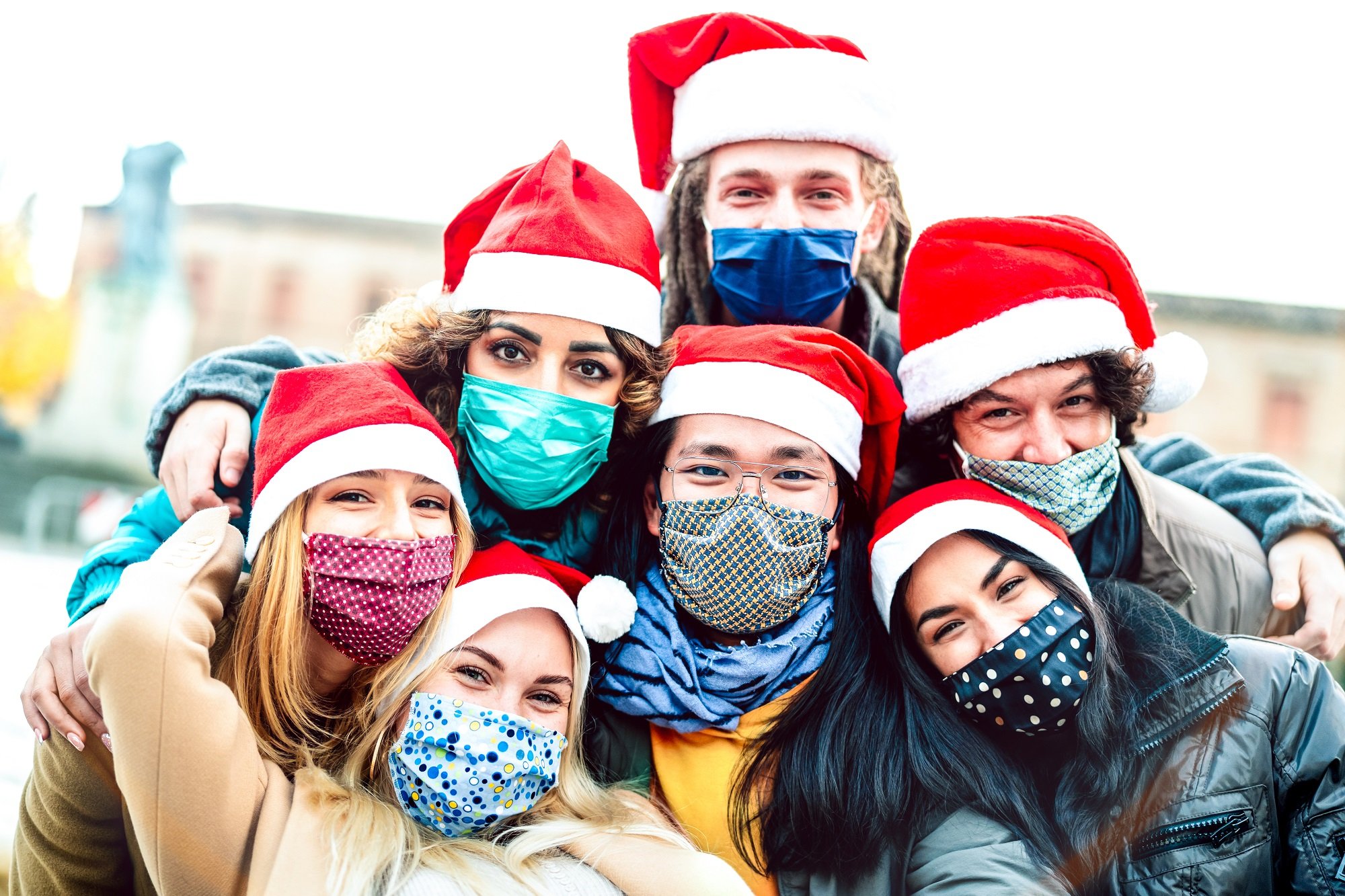 Grupo de amigos con mascarillas y gorros de Navidad. | Foto: Shutterstock