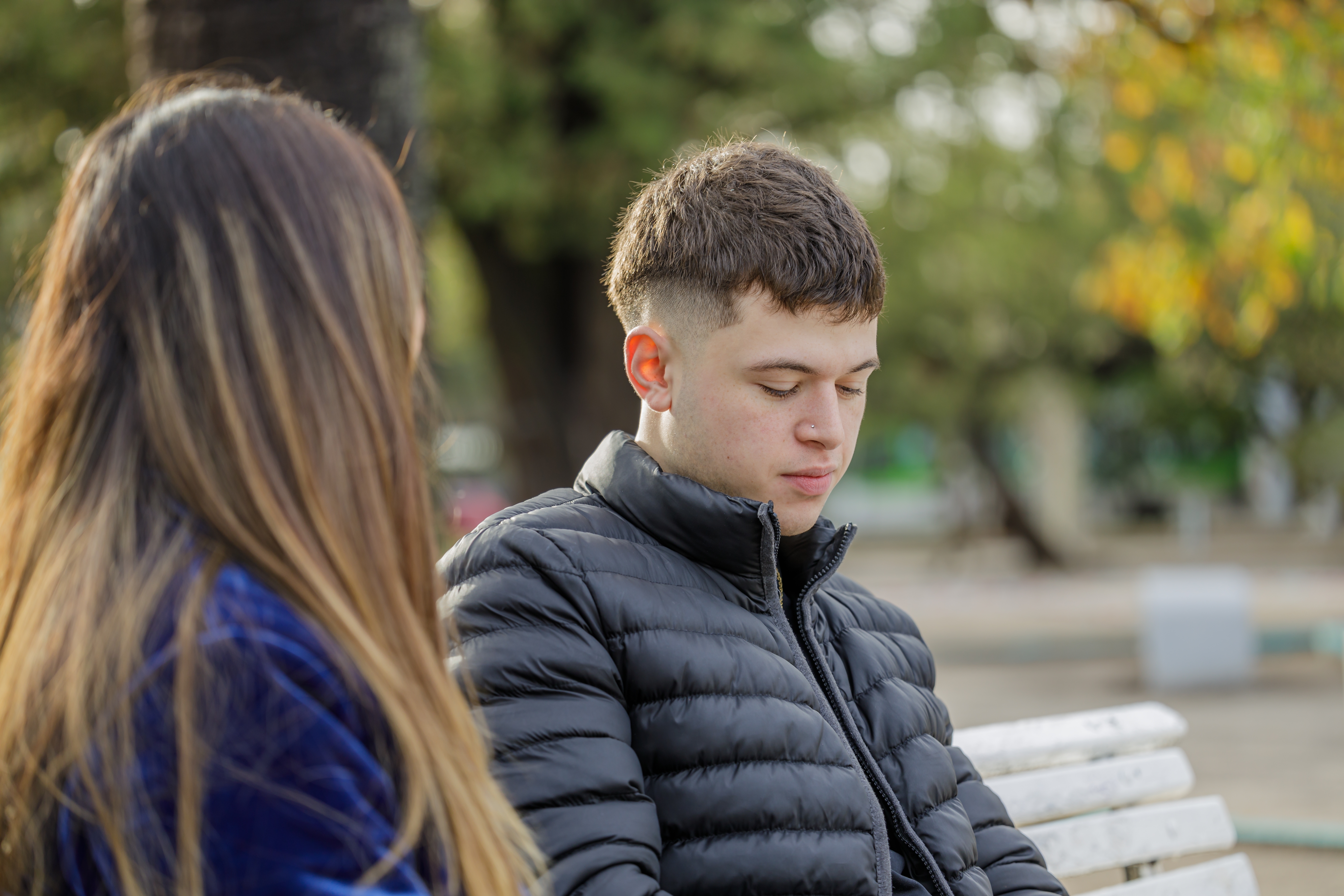 Un joven triste contando su historia a la mujer sentada a su lado | Fuente: Shutterstock