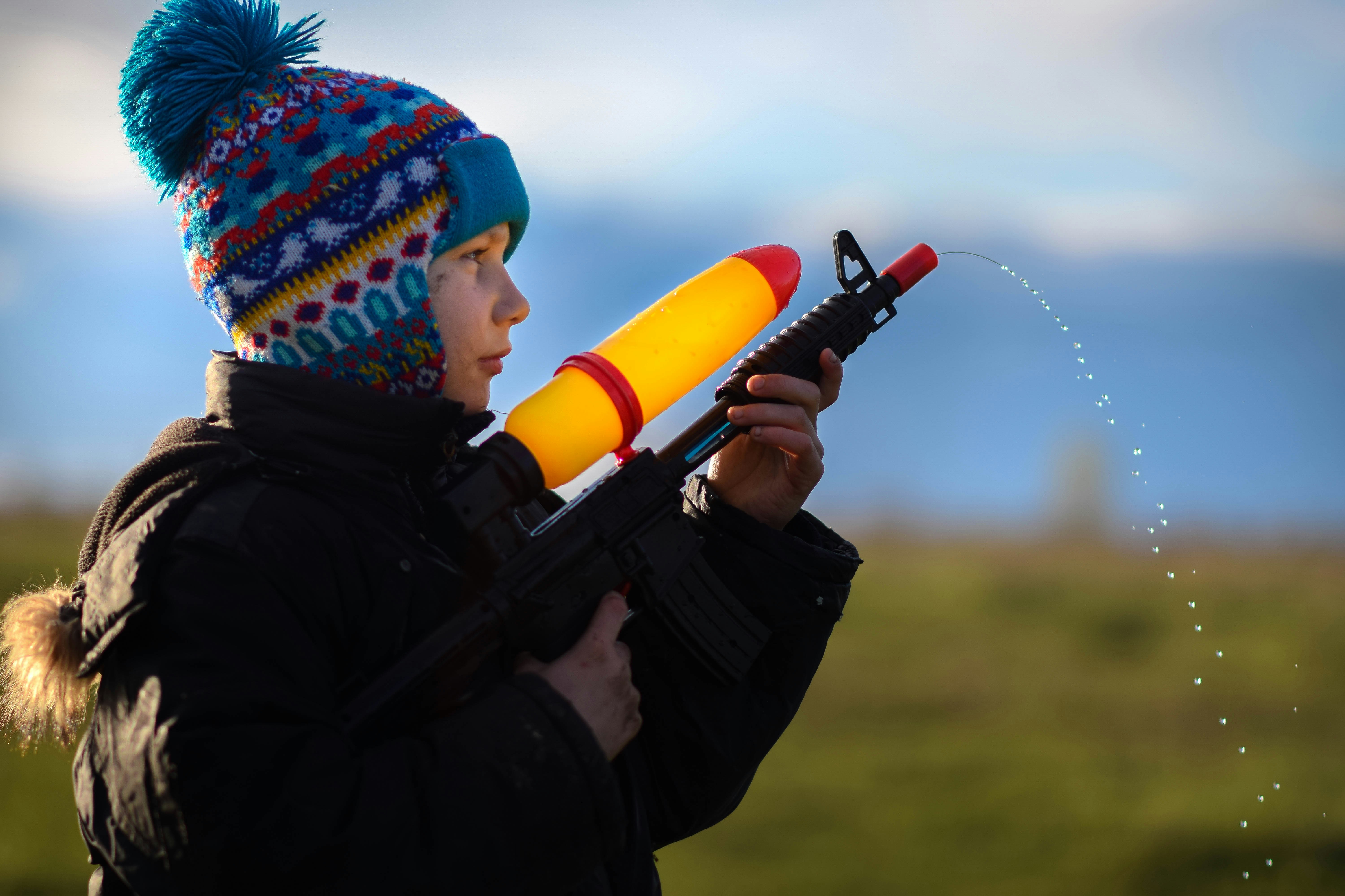 Un niño con pistolas de agua | Fuente: Unsplash