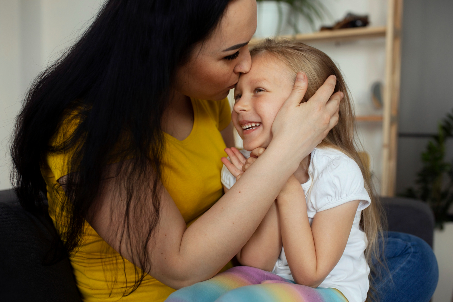 Una donna che bacia una bambina sulla fronte | Fonte: Freepik