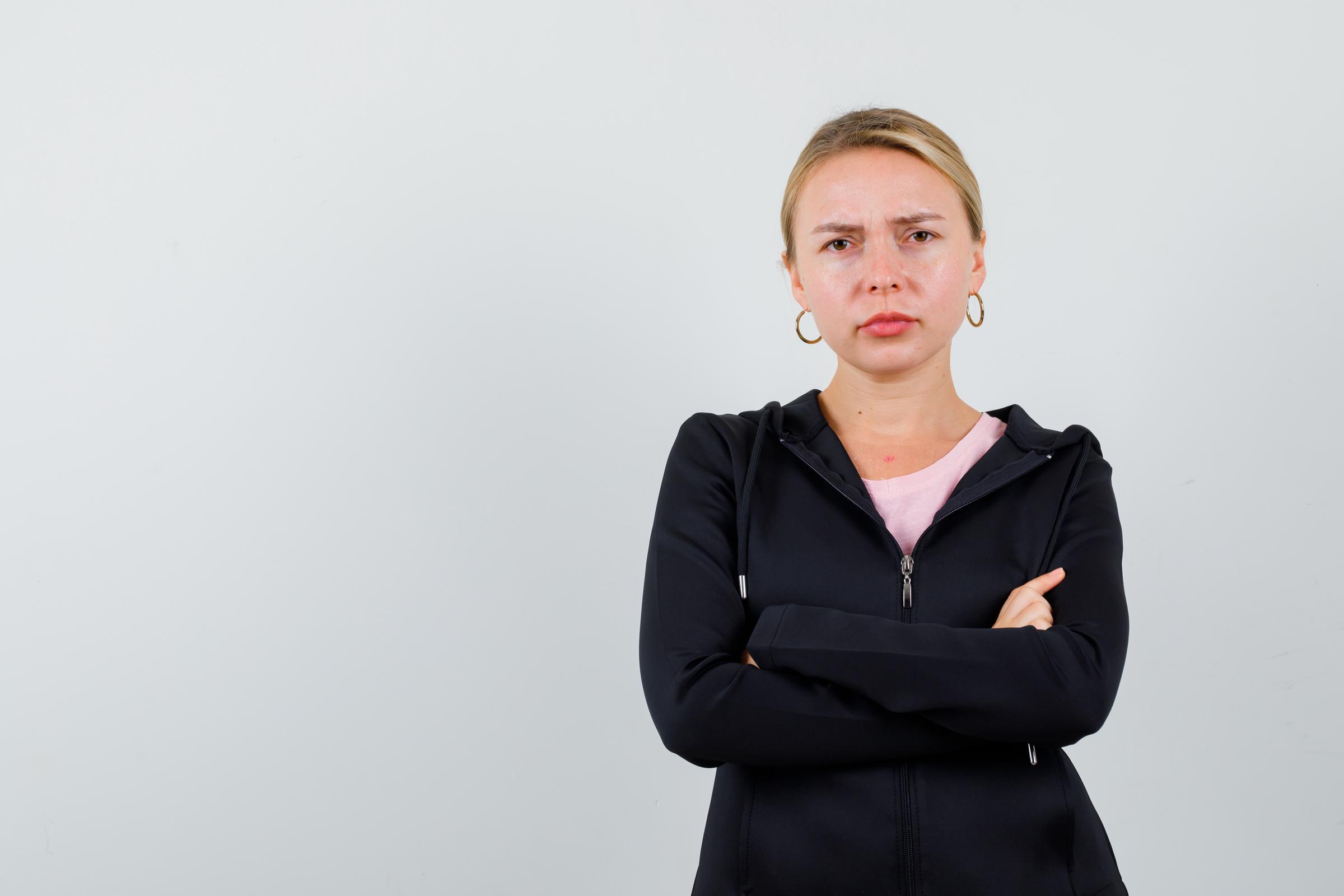 Una mujer seria con los brazos cruzados | Fuente: Freepik