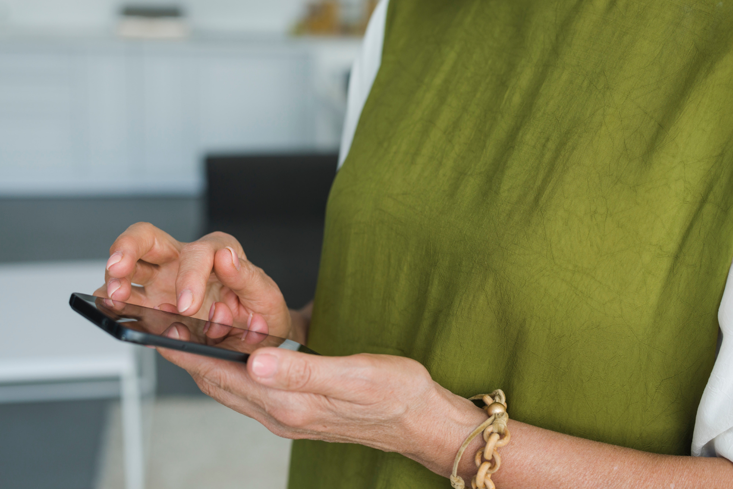 Una mujer mayor sujetando su teléfono | Fuente: Freepik