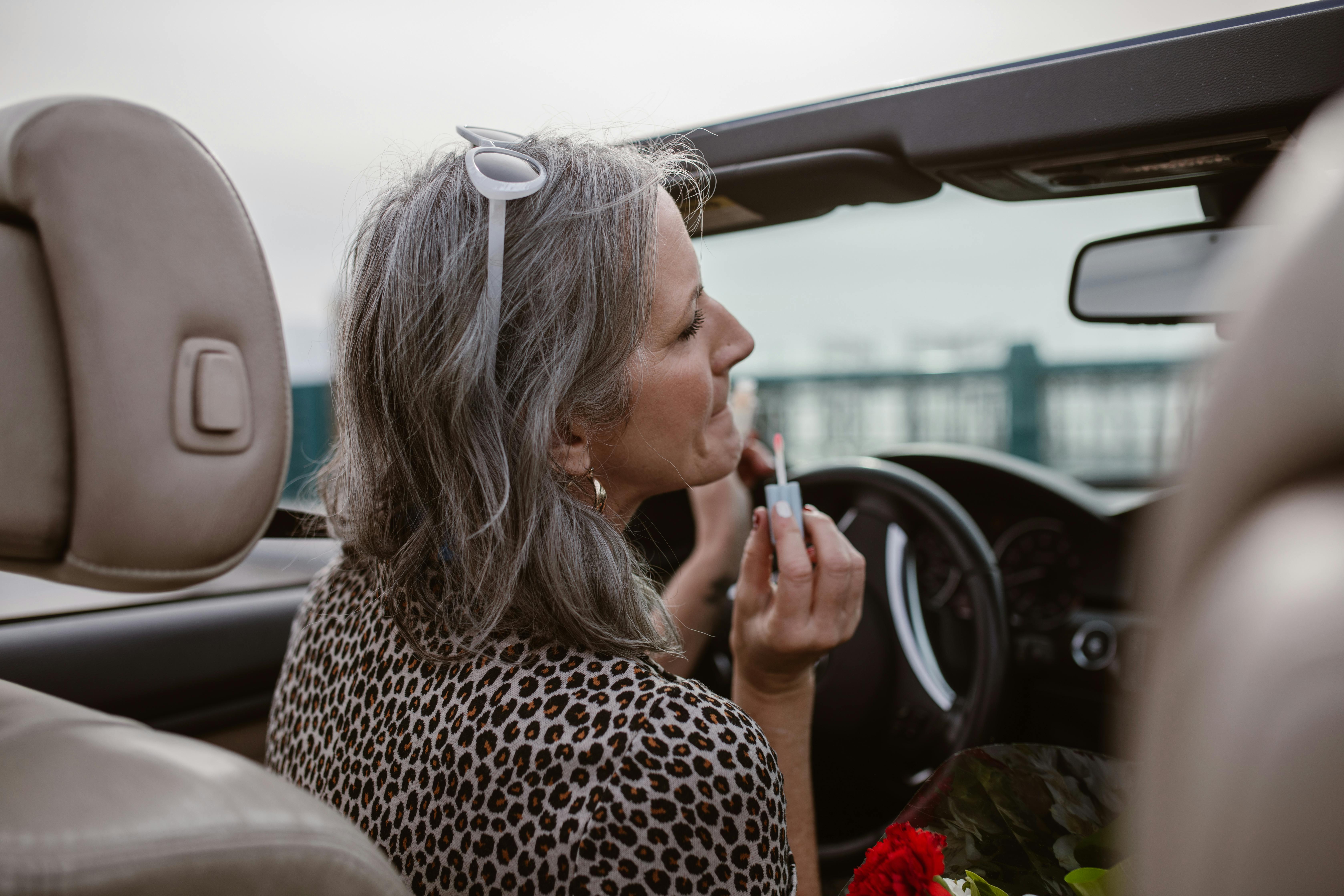 Una mujer pintándose los labios mientras conduce | Foto: Pexels