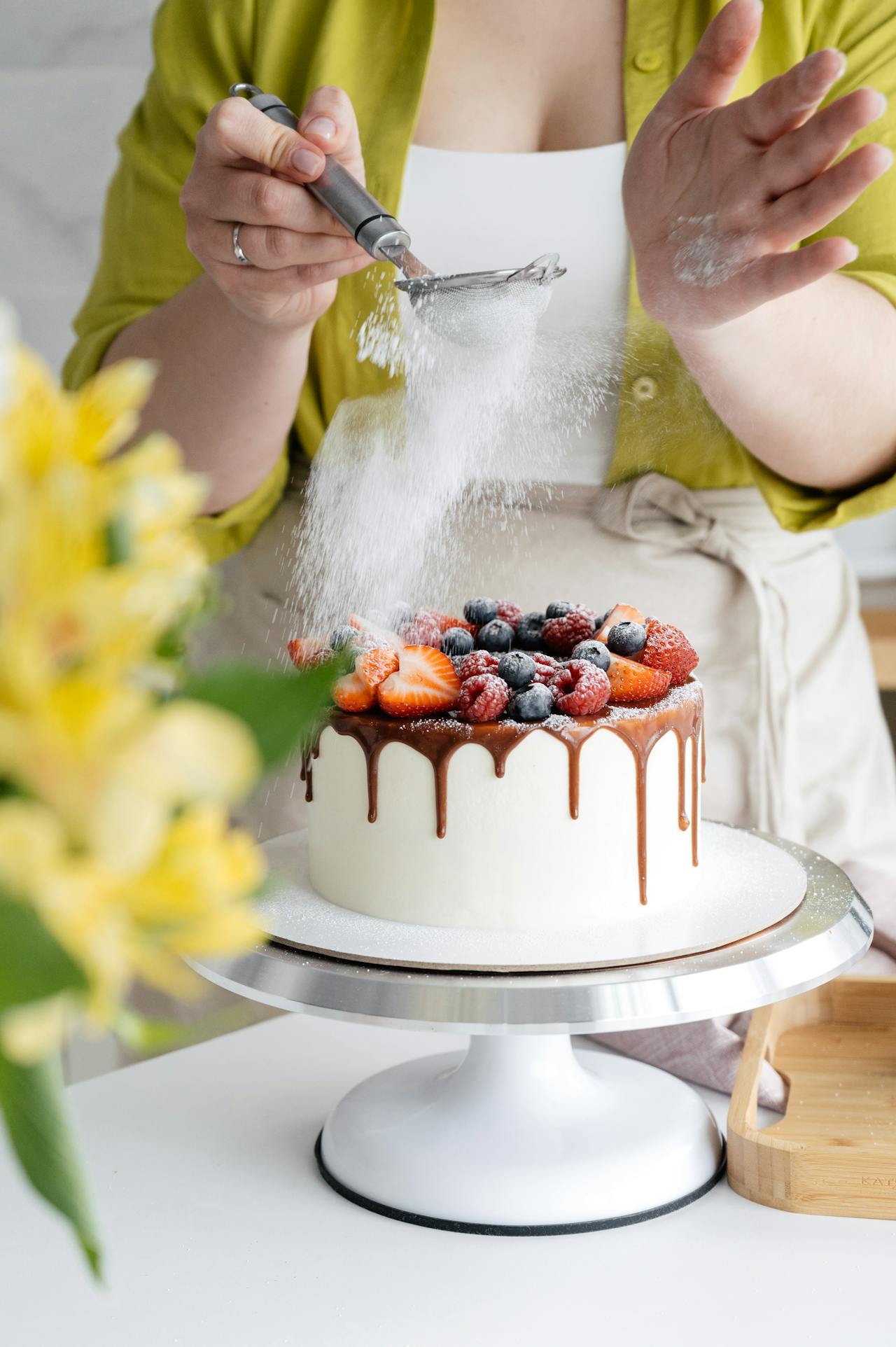Una mujer decorando un pastel | Fuente: Pexels