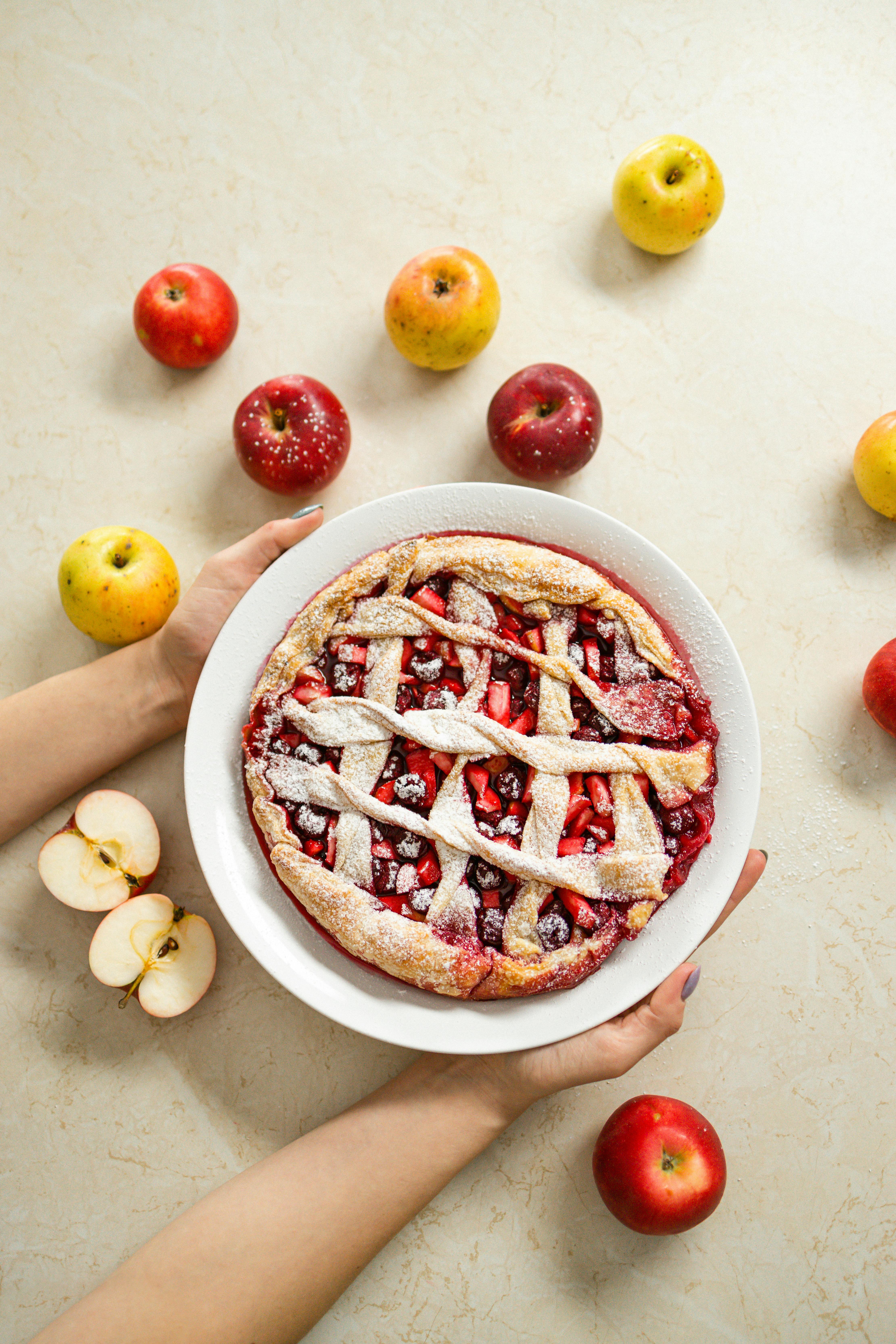 Plato de tarta de manzana sostenido por una persona | Foto: Pexels