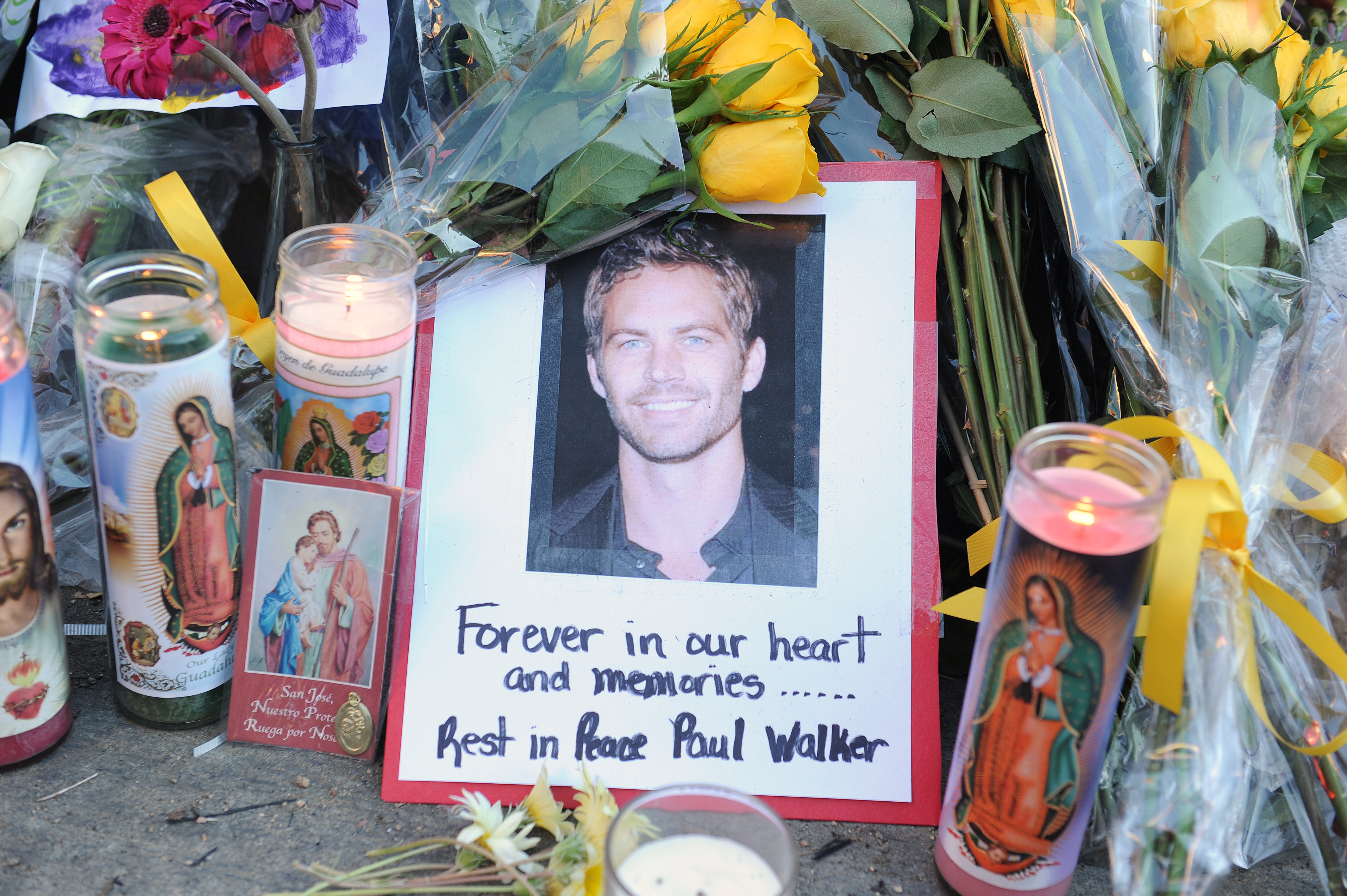 Foto de Paul walker con flores y velas donde ocurrió su accidente en California, en 2013, | Foto: Getty Images