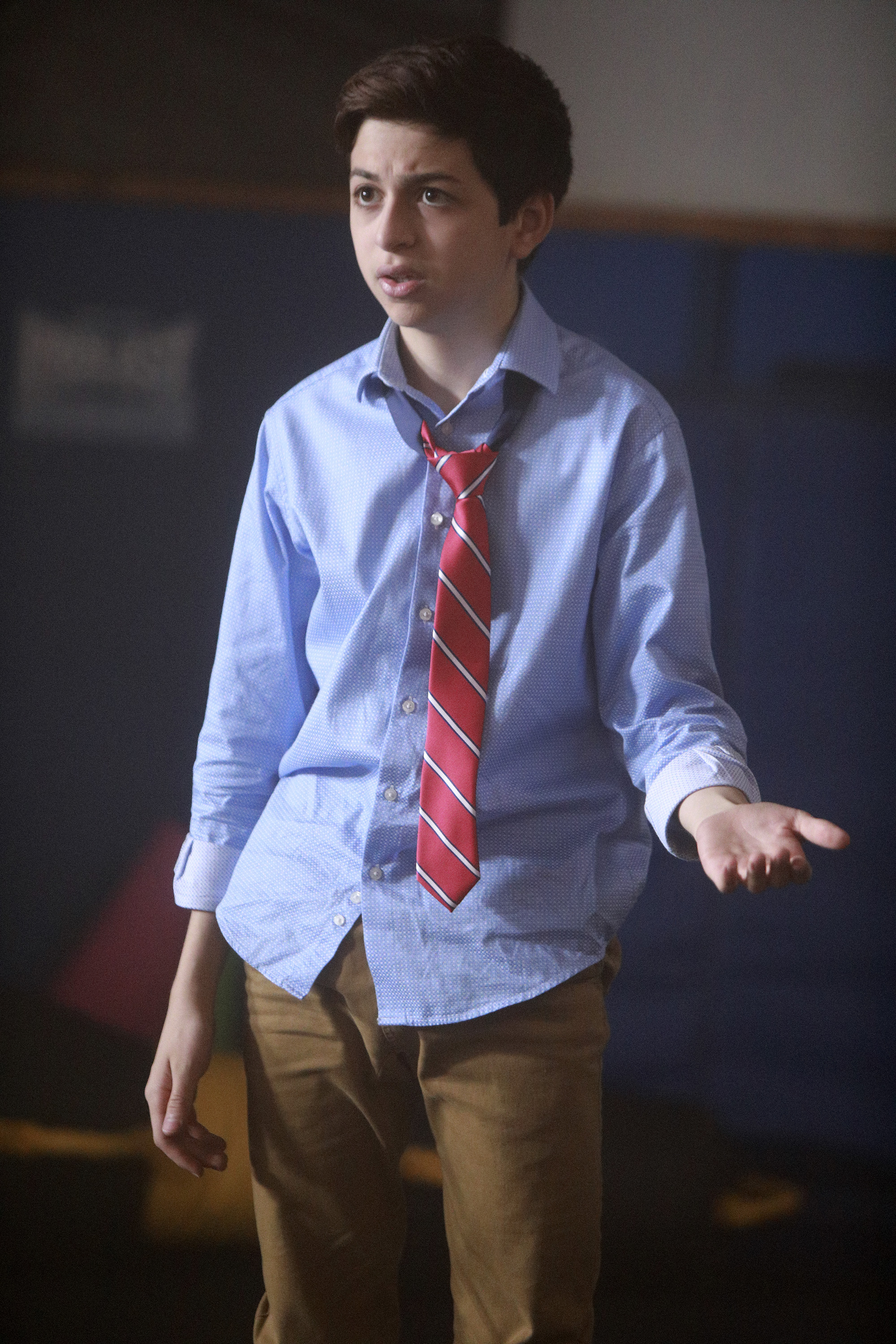 J.J. Totah interpreta a Michael en "Champions", con una camisa azul claro abotonada, una corbata a rayas rojas atada sin apretar y unos pantalones marrones, en una escena de la serie de televisión. | Fuente: Getty Images