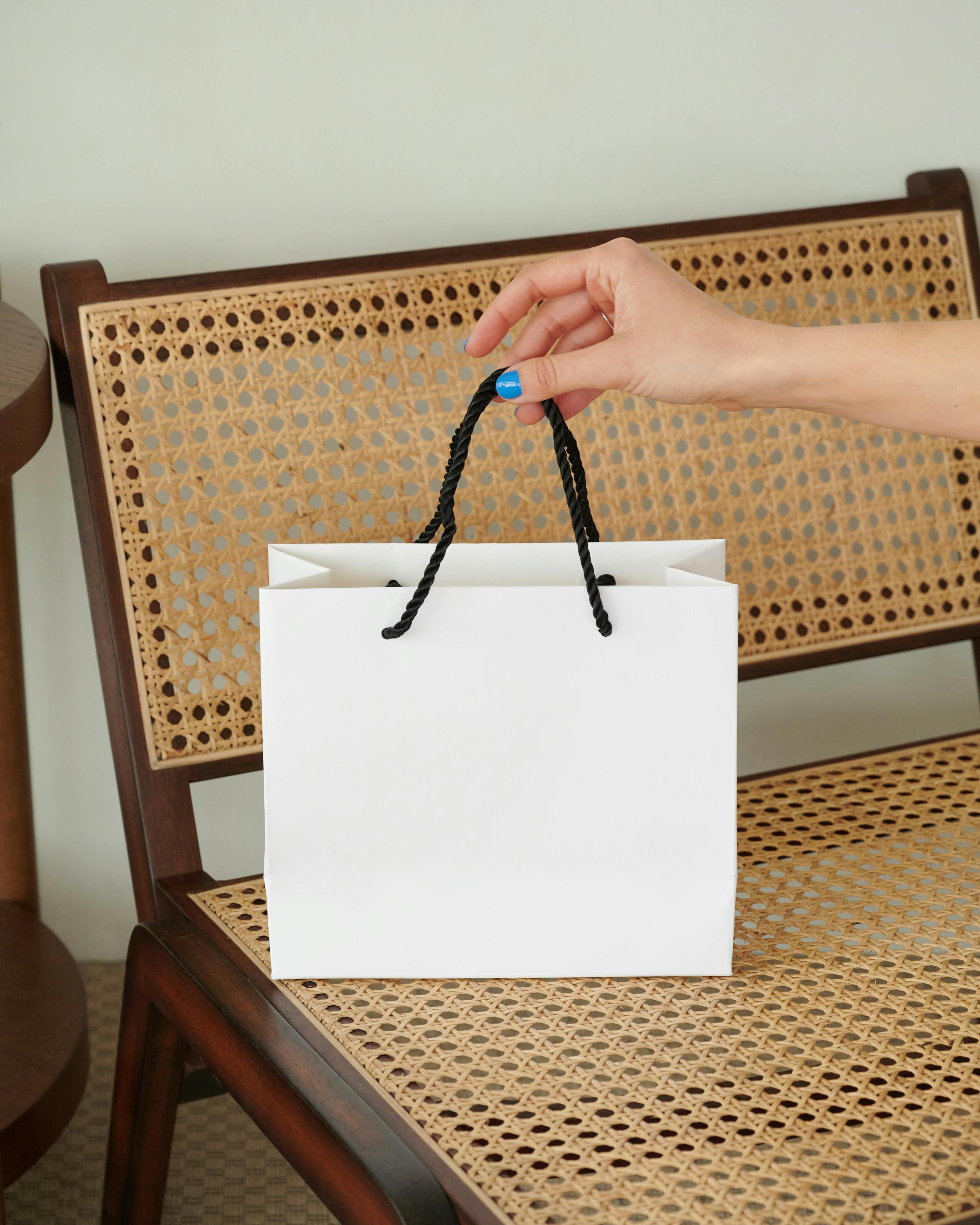 Una persona con una bolsa de regalo blanca | Fuente: Pexels