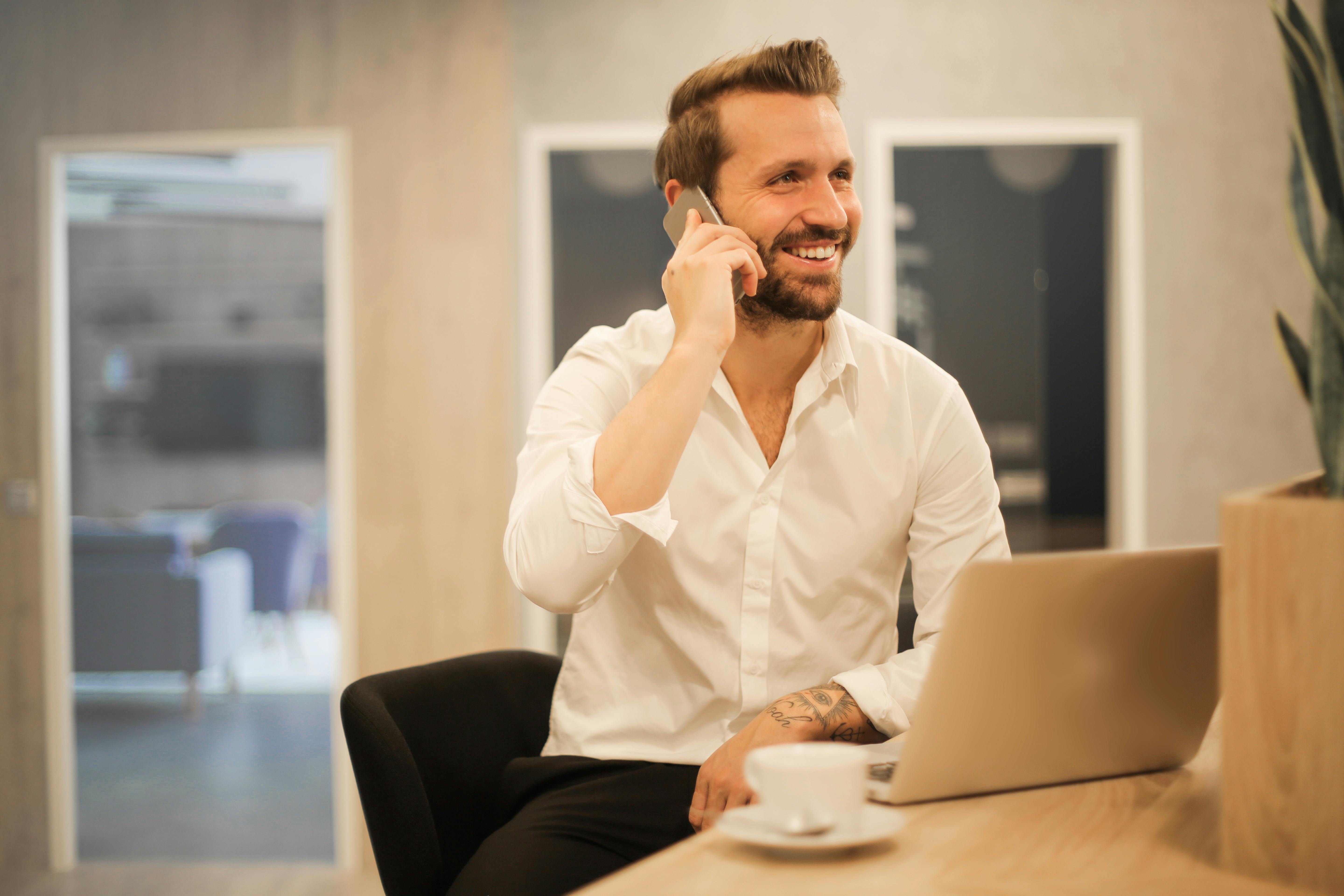 Un hombre sonriendo al teléfono | Fuente: Pexels