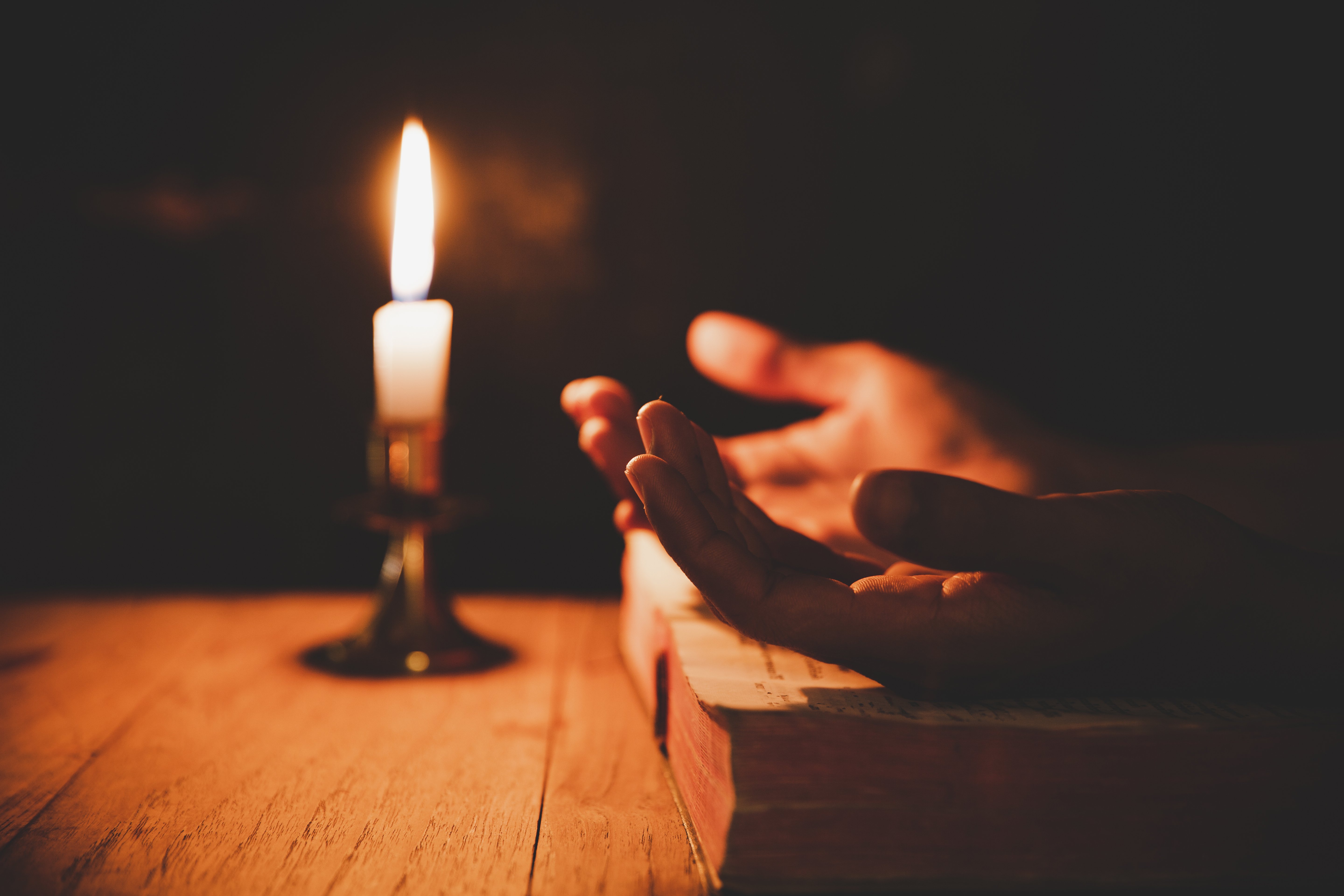 Manos junto a una vela Foto: Shutterstock