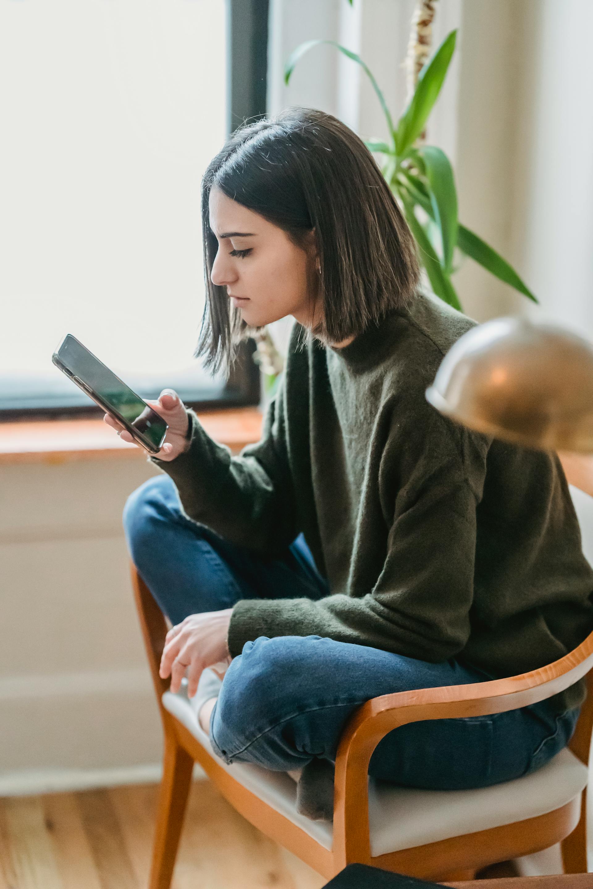 Una mujer sujetando su móvil | Fuente: Pexels