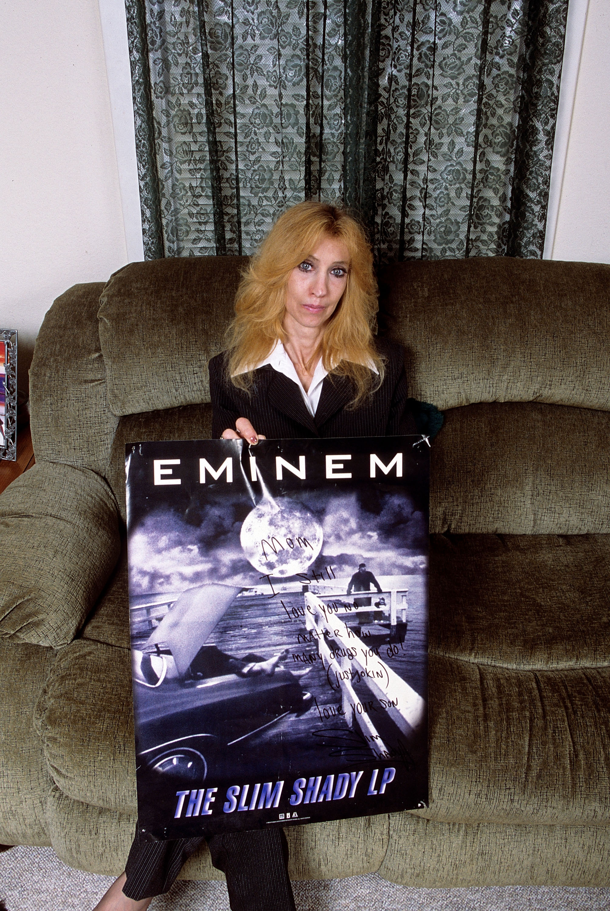 Debbie Nelson sostiene un póster manuscrito de Eminem en su casa de Detroit en septiembre de 2005 | Fuente: Getty Images