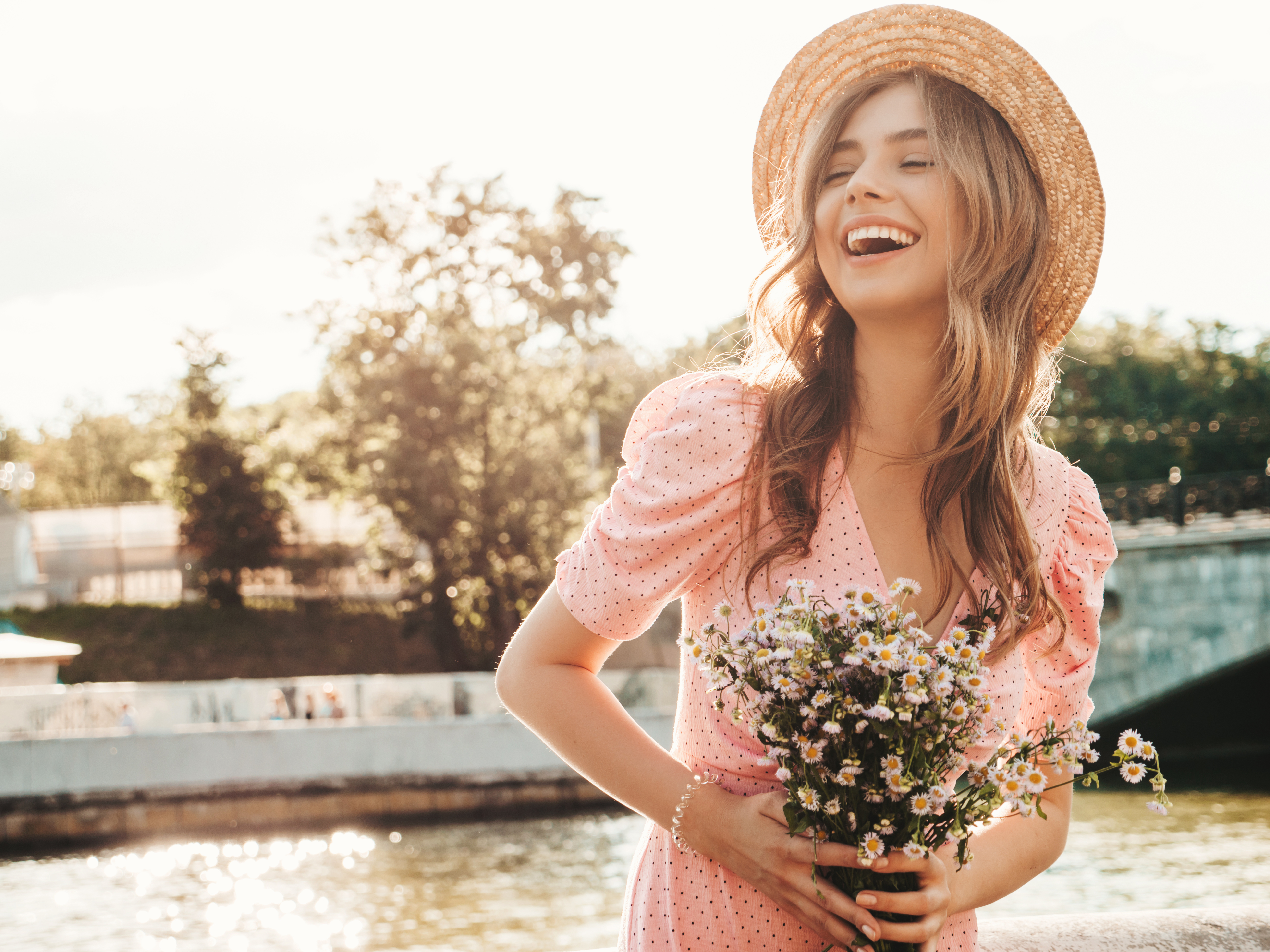 Una joven sonriente sosteniendo flores | Fuente: Shutterstock