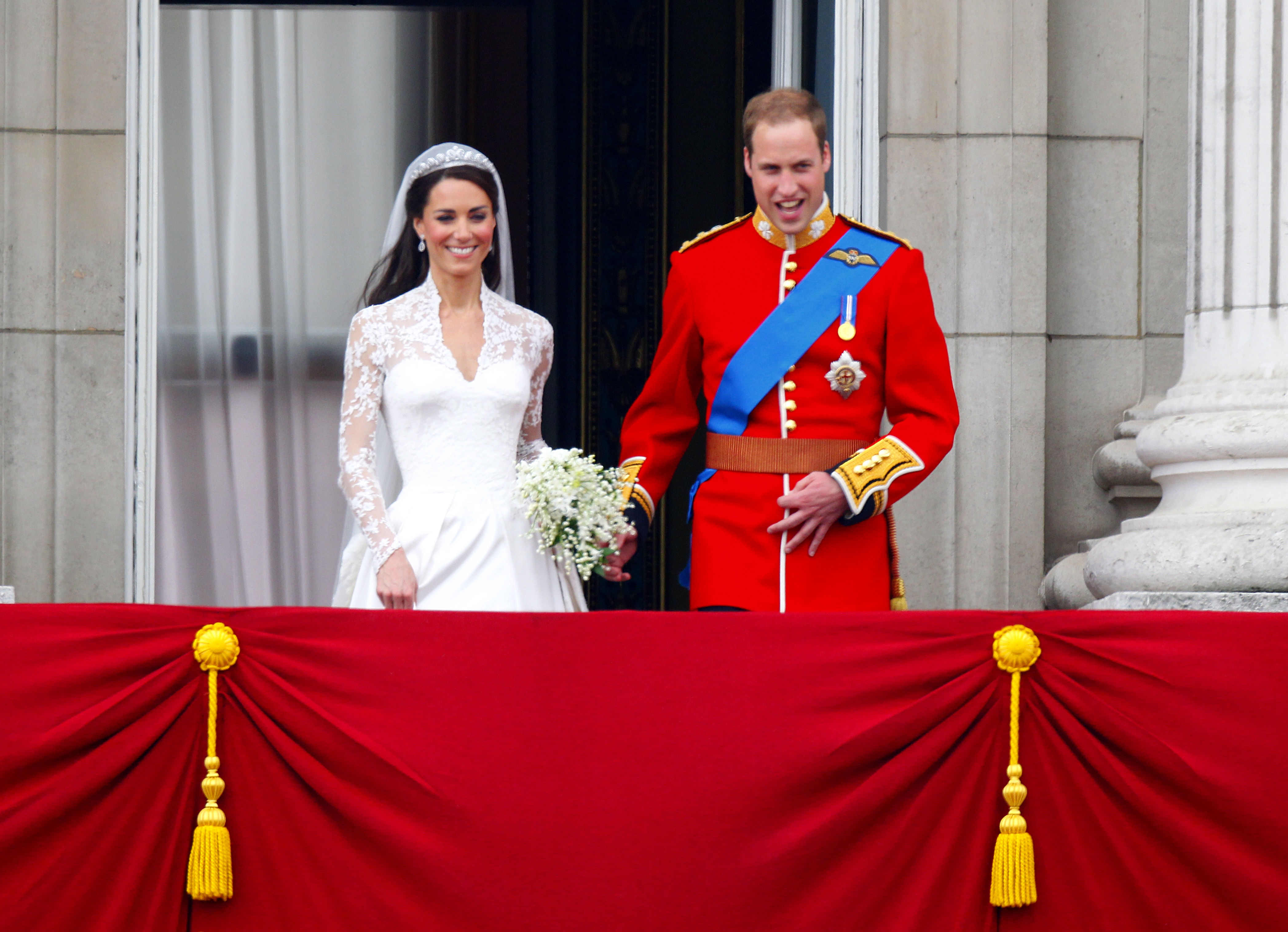 Catherine, Duquesa de Cambridge, y el príncipe William saludan a la multitud en el balcón del Palacio de Buckingham en Londres, tras su boda el 29 de abril de 2011 | Fuente: Getty Images