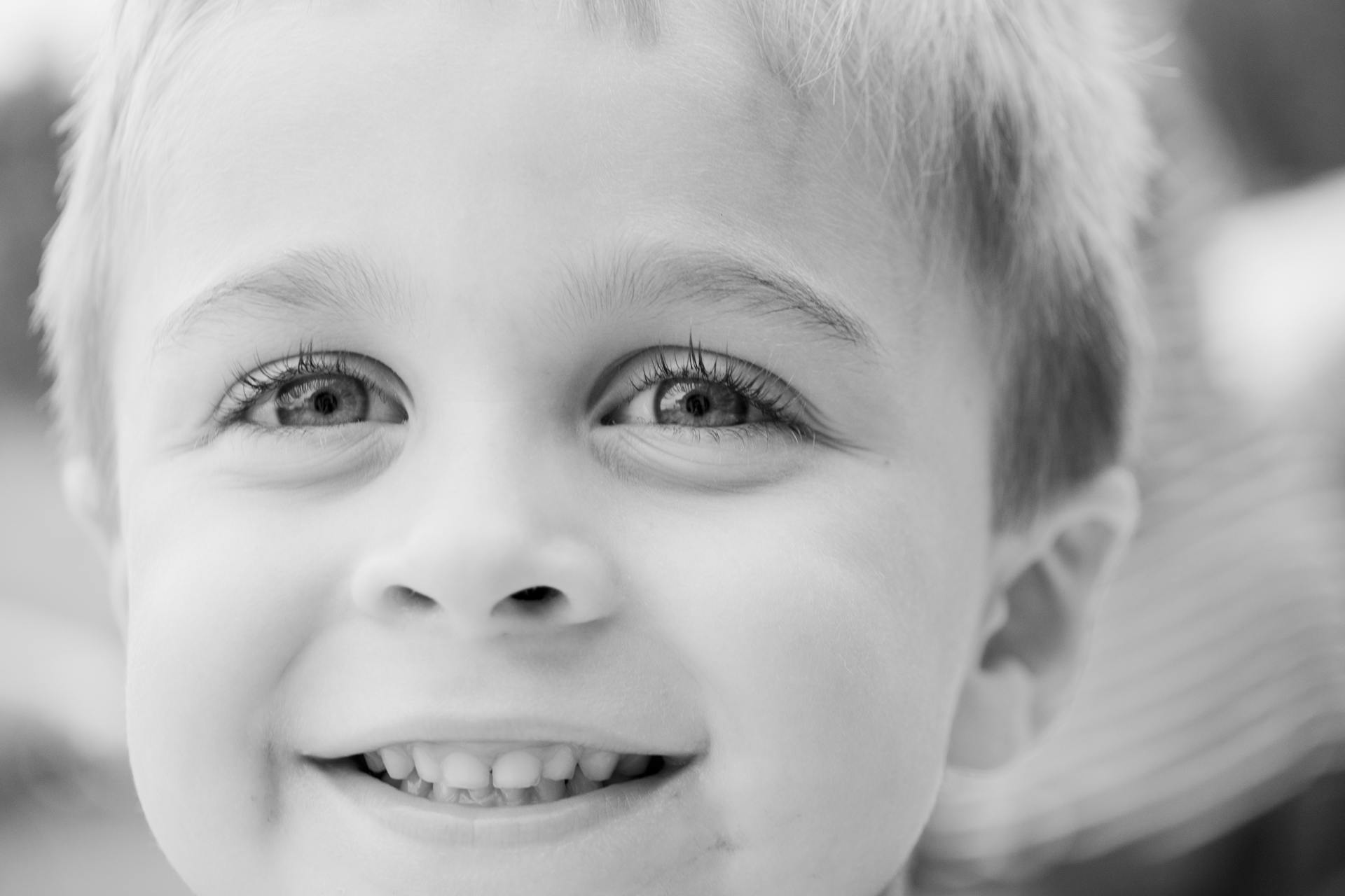 Retrato en escala de grises de un niño sonriente | Fuente: Pexels