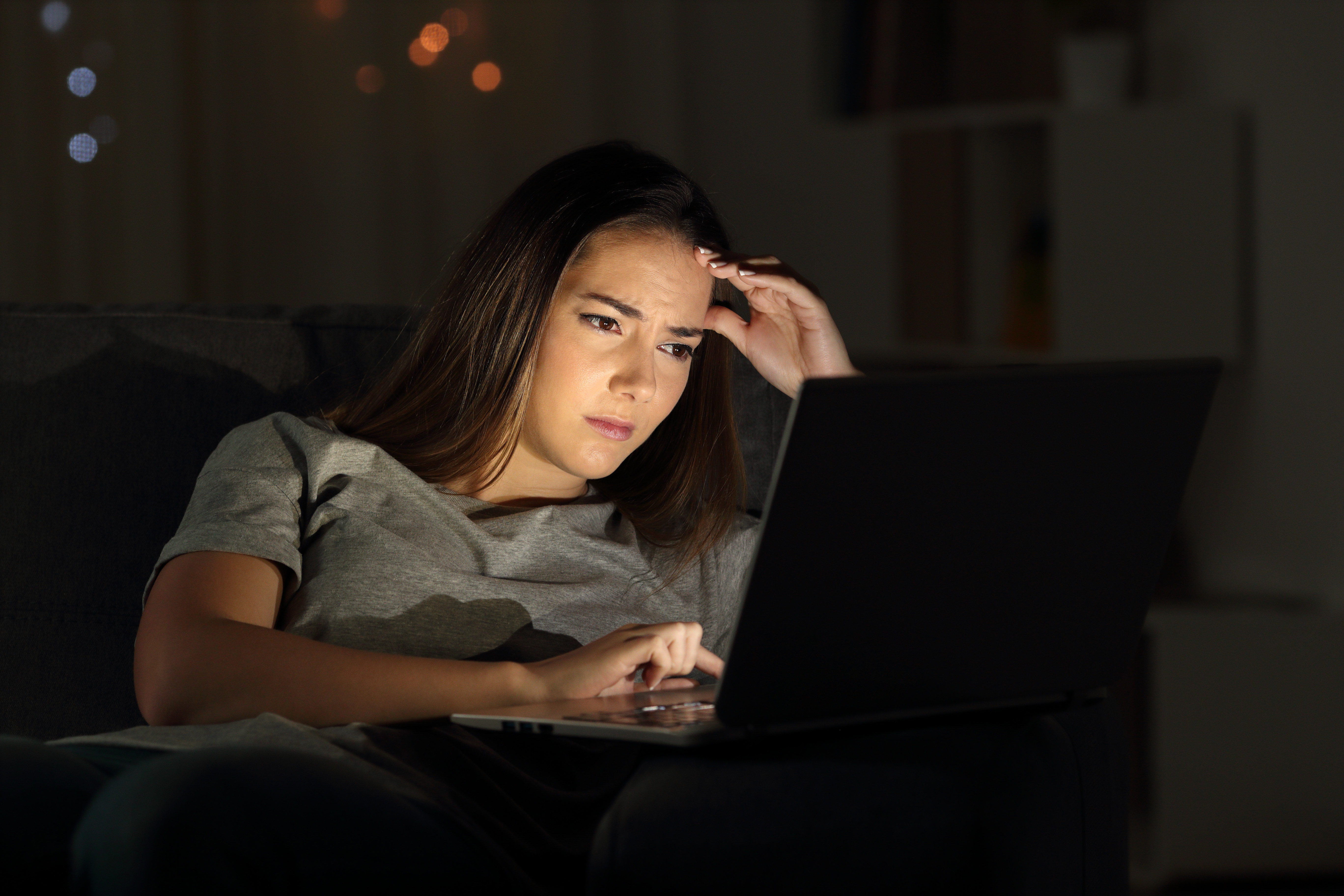 Una mujer preocupada utilizando su portátil | Fuente: Shutterstock