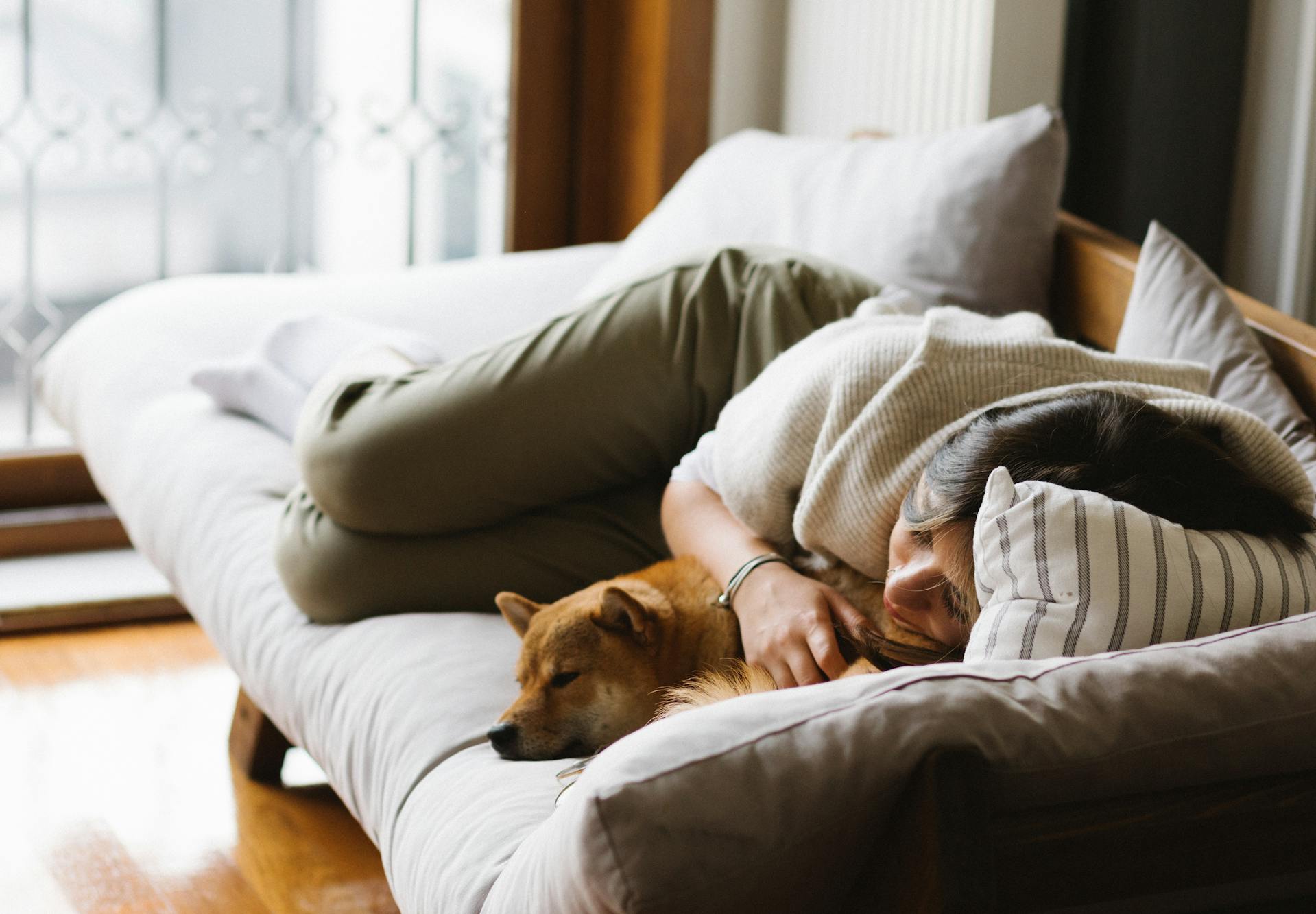 Una mujer acurrucada en un sofá | Fuente: Pexels