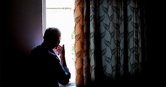 Hombre mirando por la ventana | Fuente: Shutterstock