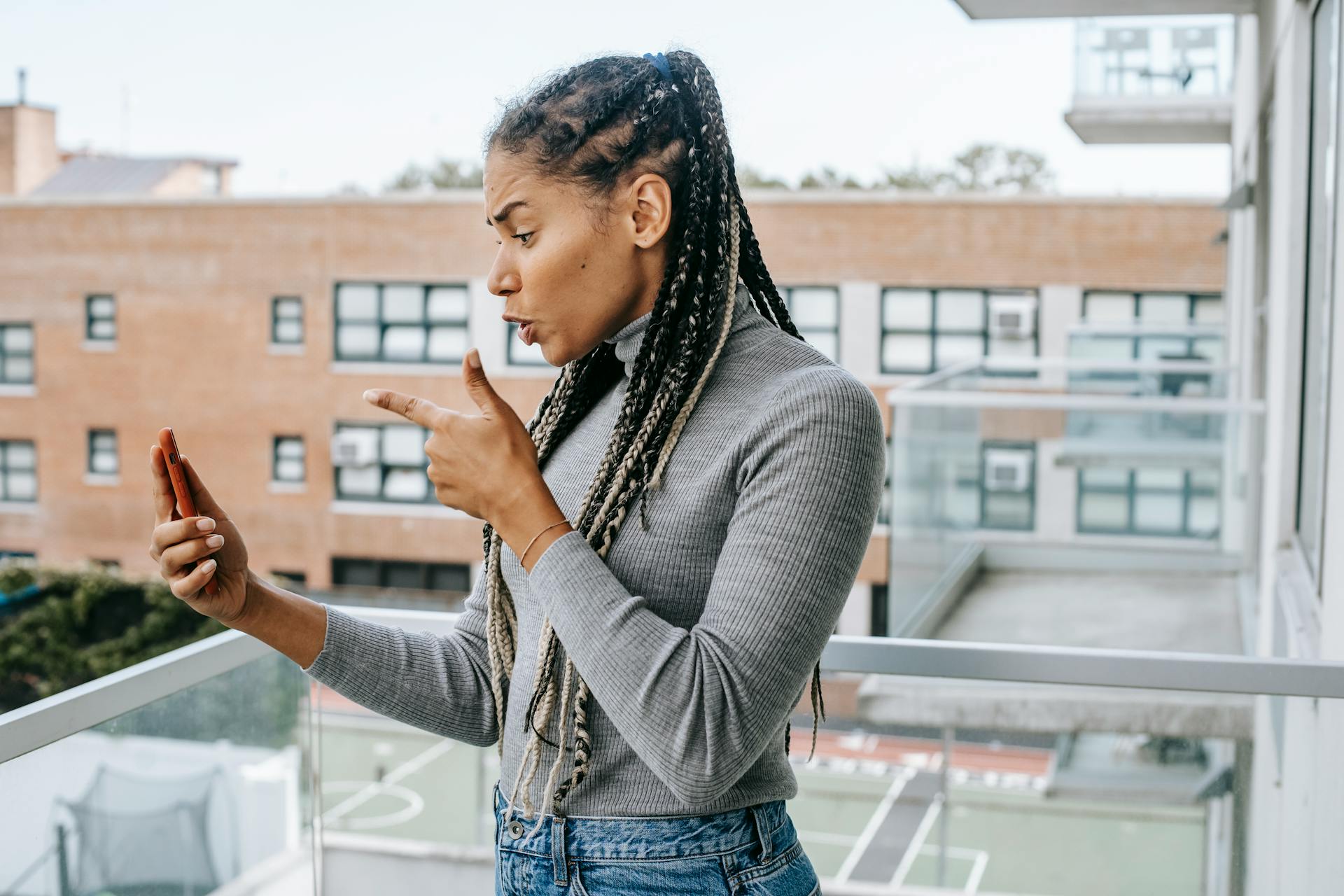 Una mujer furiosa haciendo gestos con las manos mientras mantiene una conversación de vídeo con alguien en su teléfono | Fuente: Pexels