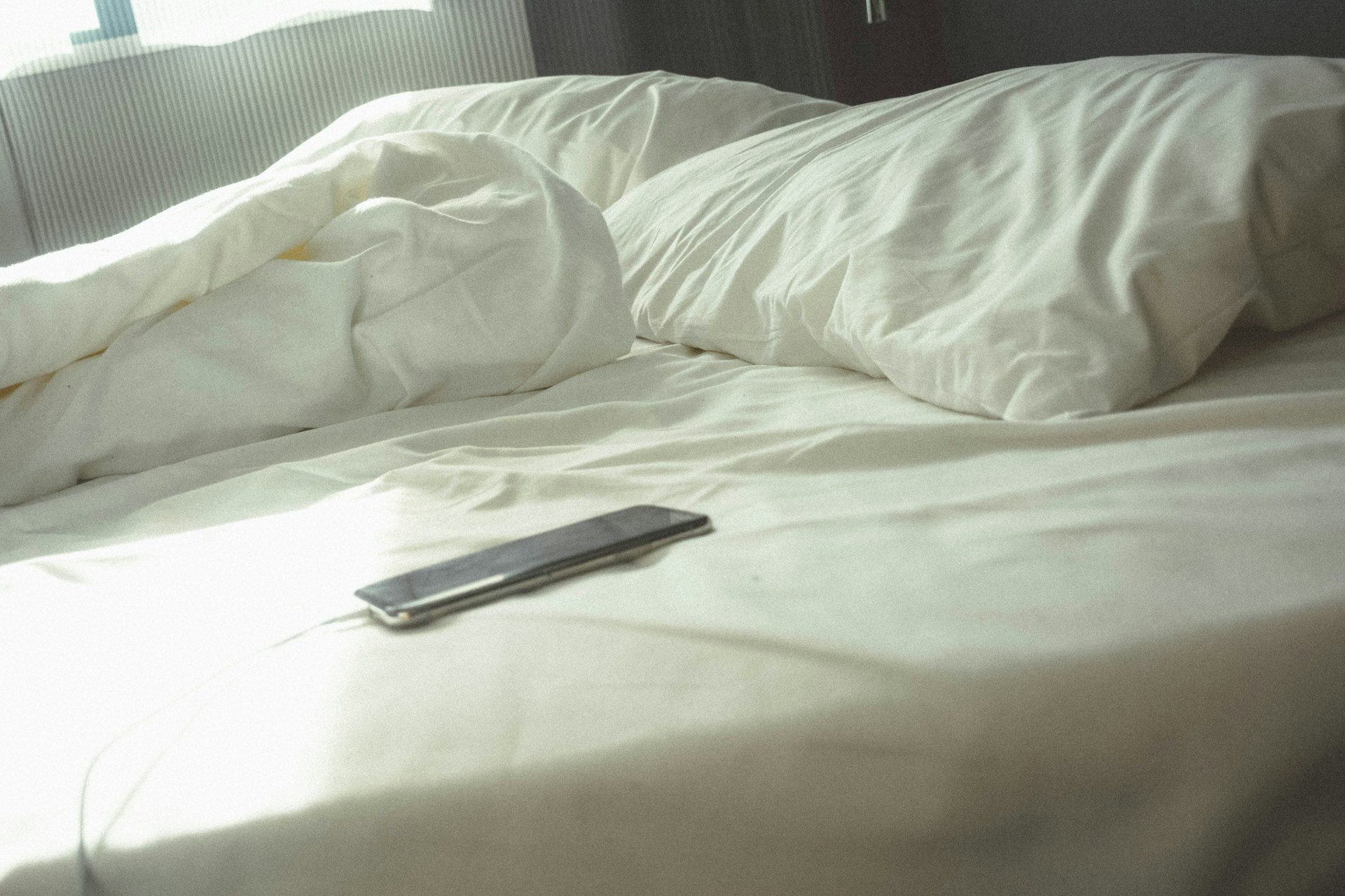 Un teléfono sobre la cama | Fuente: Unsplash