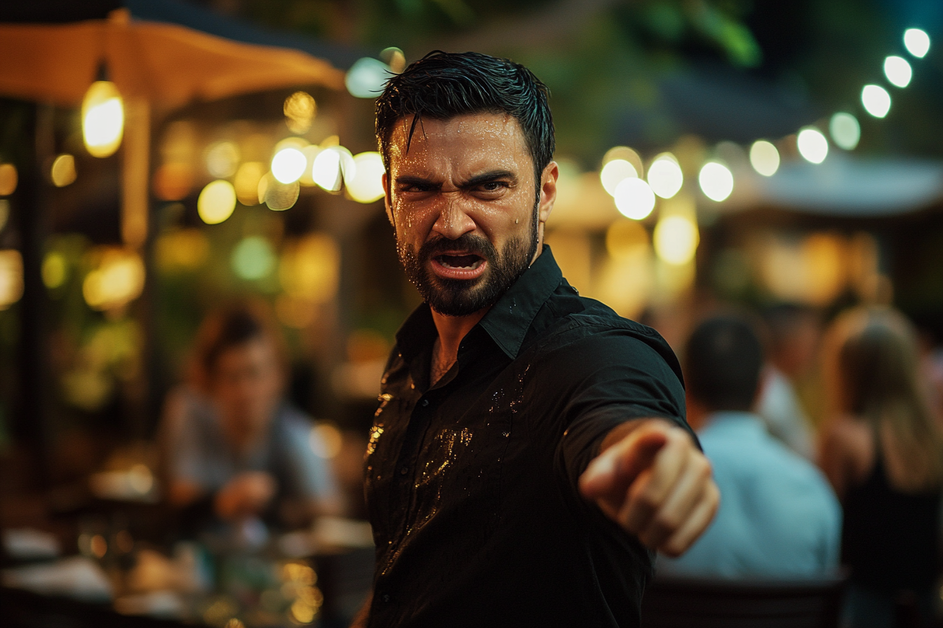 Un hombre cubierto de refresco gritando y señalando enfadado, de pie en un restaurante | Fuente: Midjourney