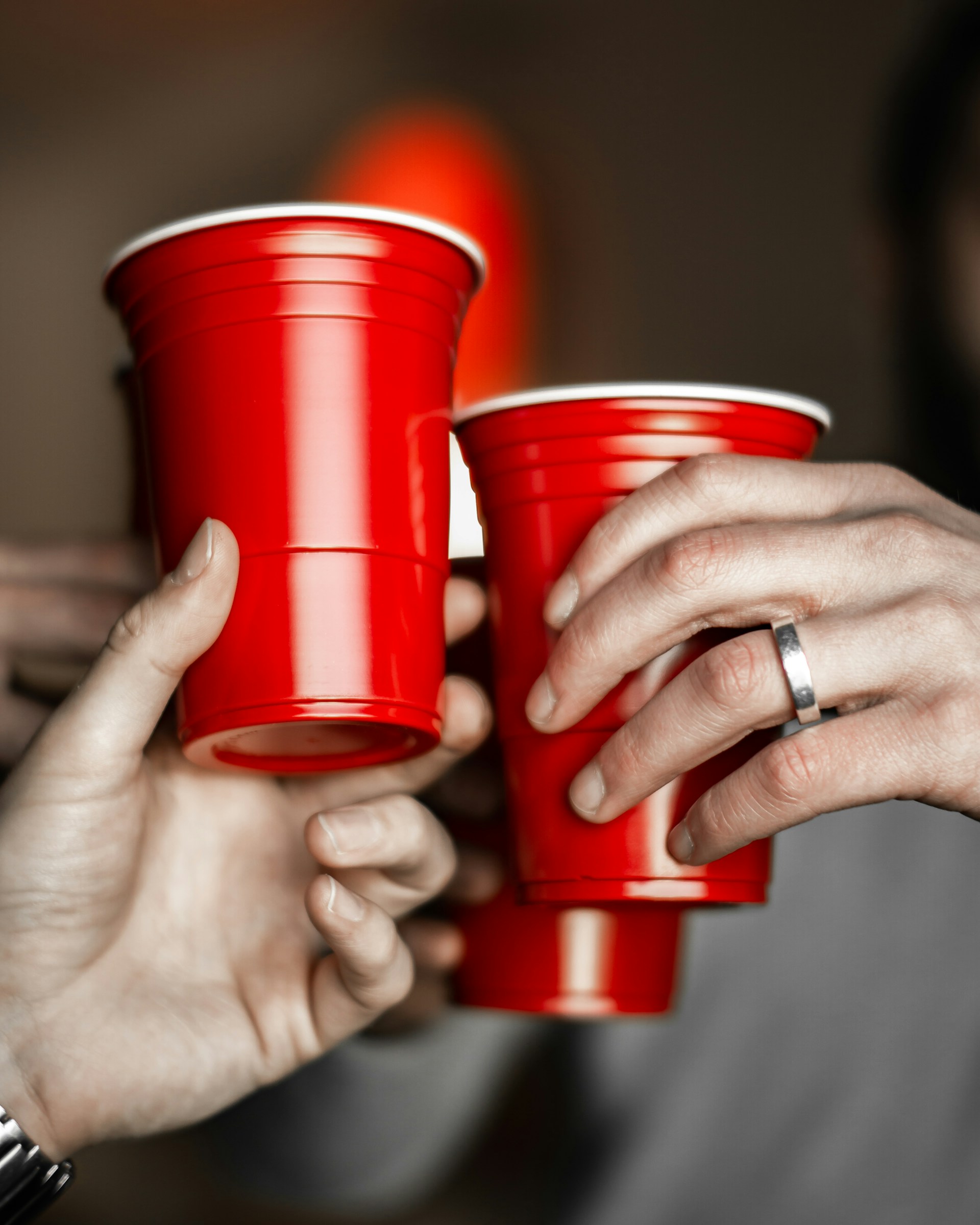 Un grupo de hombres sosteniendo tazas rojas | Fuente: Unsplash