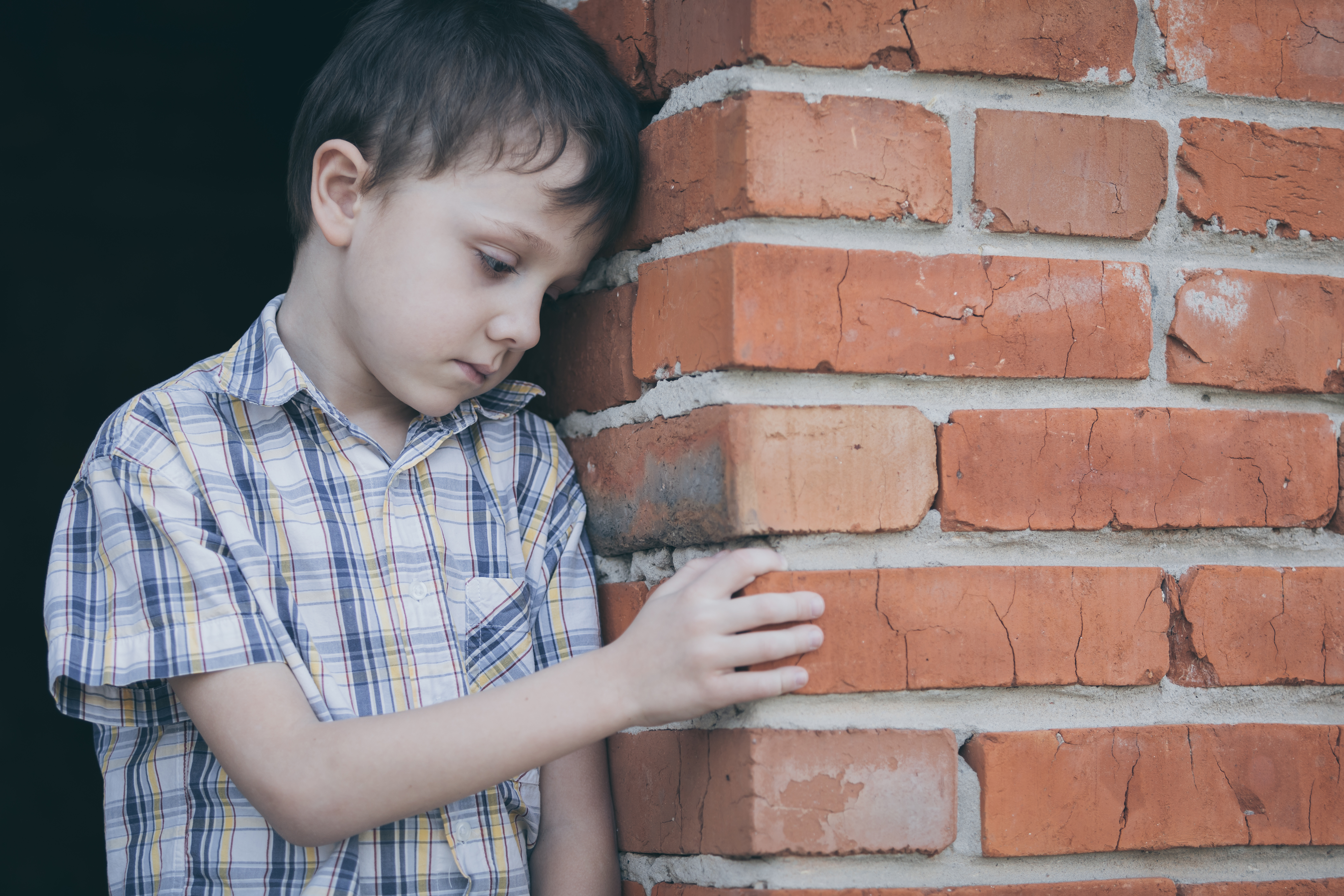 Retrato de niño triste al aire libre de día. | Fuente: Shutterstock
