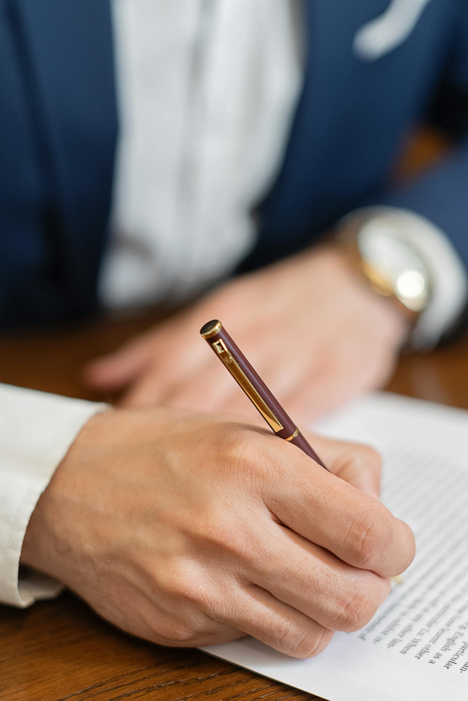 Un primo piano di una persona che firma un documento | Fonte: Pexels