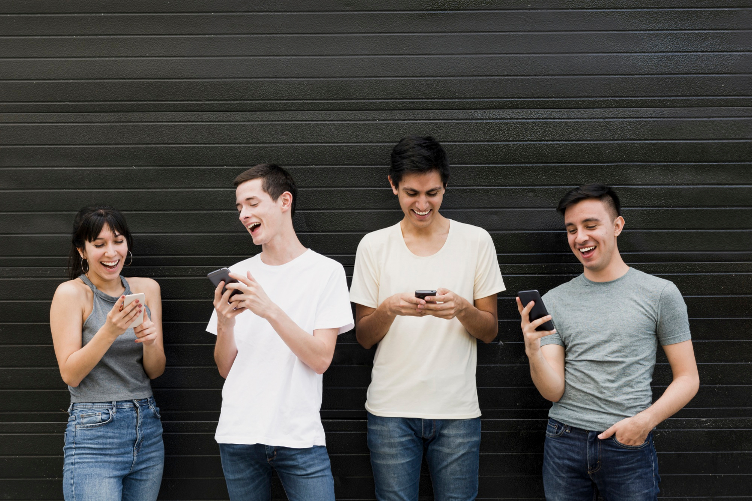 Un grupo de personas emocionadas sujetando sus teléfonos móviles | Fuente: Freepik