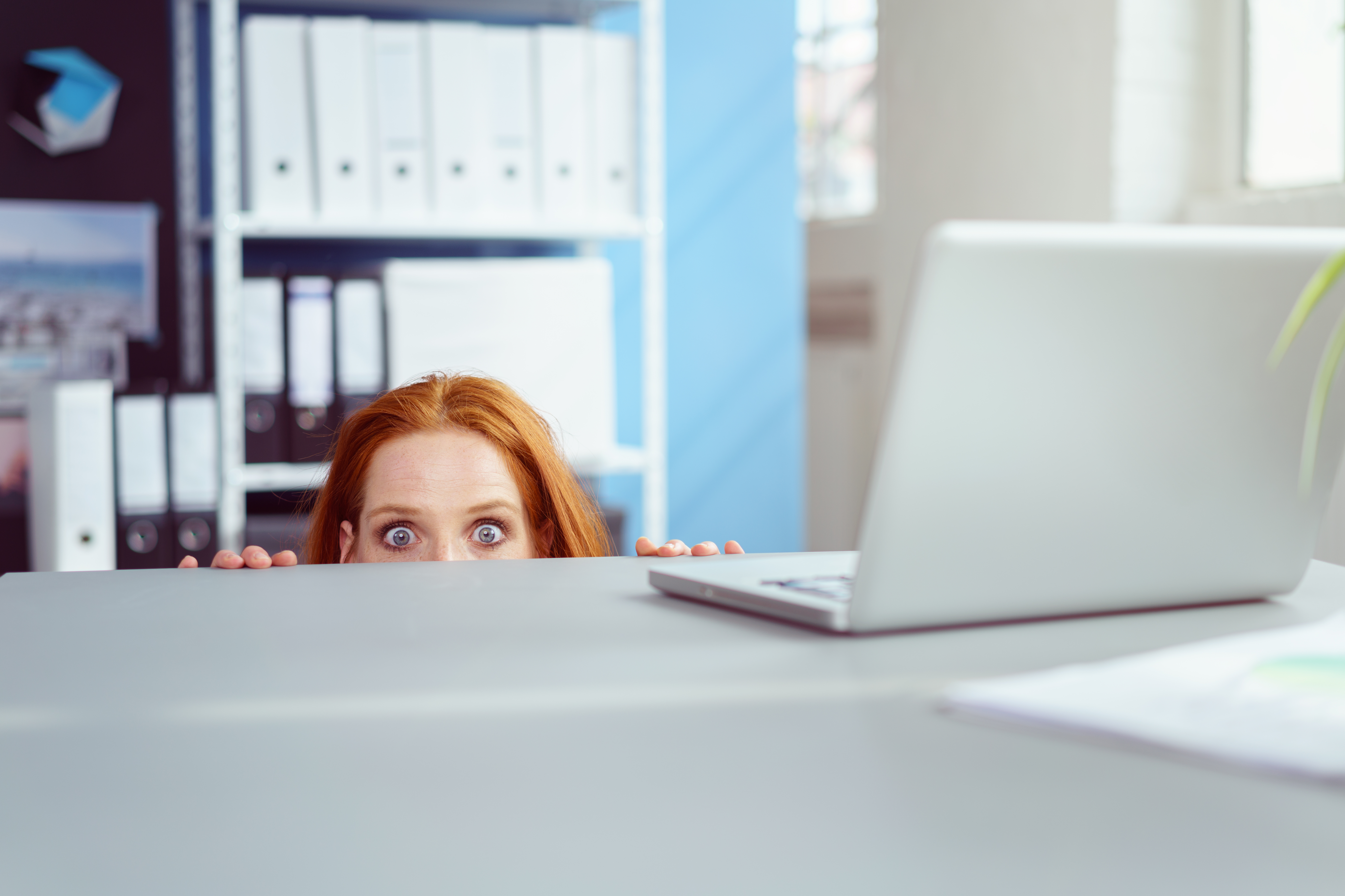 Mujer escondida bajo un escritorio | Foto: Shutterstock